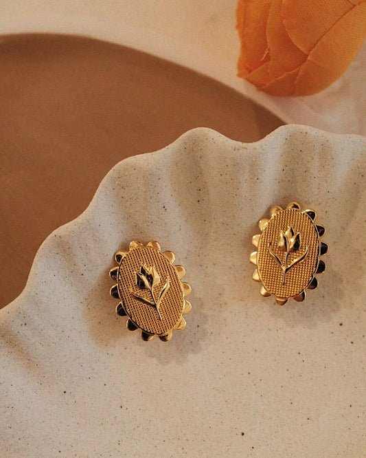 Golden Tulip Earrings on a ceramic dish, featuring 18k Gold Vermeil with tulip design, by SUIHE Jewelry. Delicate and elegant.