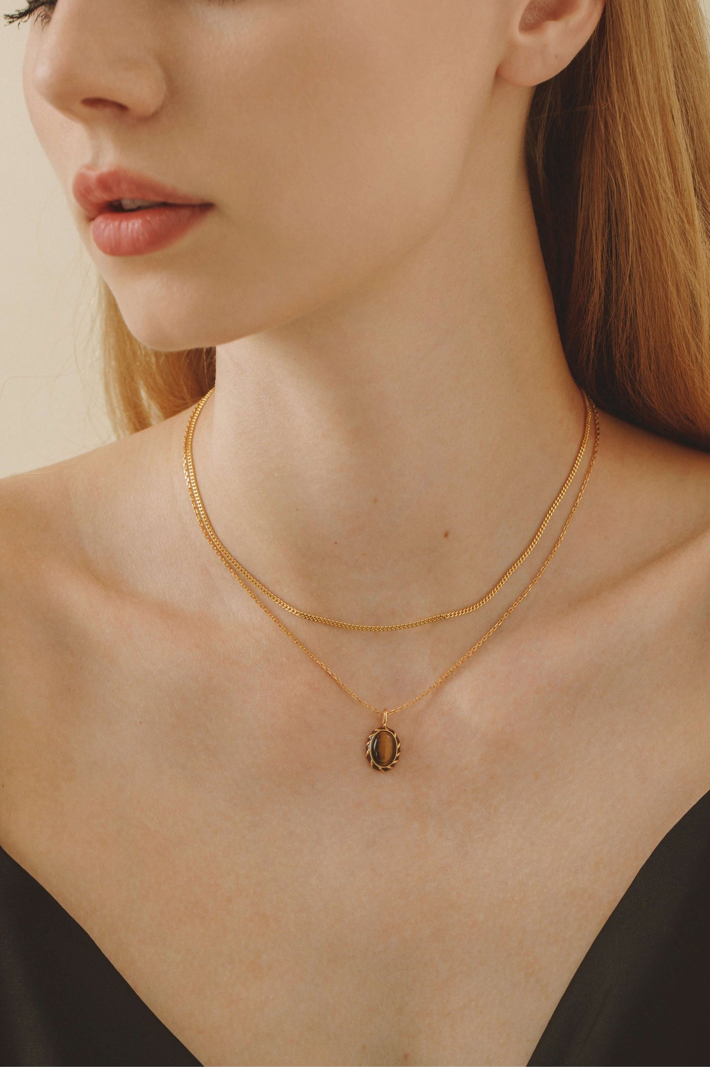 Woman wearing "Classic" Necklace by SUIHE Jewelry, showcasing 18k gold vermeil layered with other pieces for an elegant look.