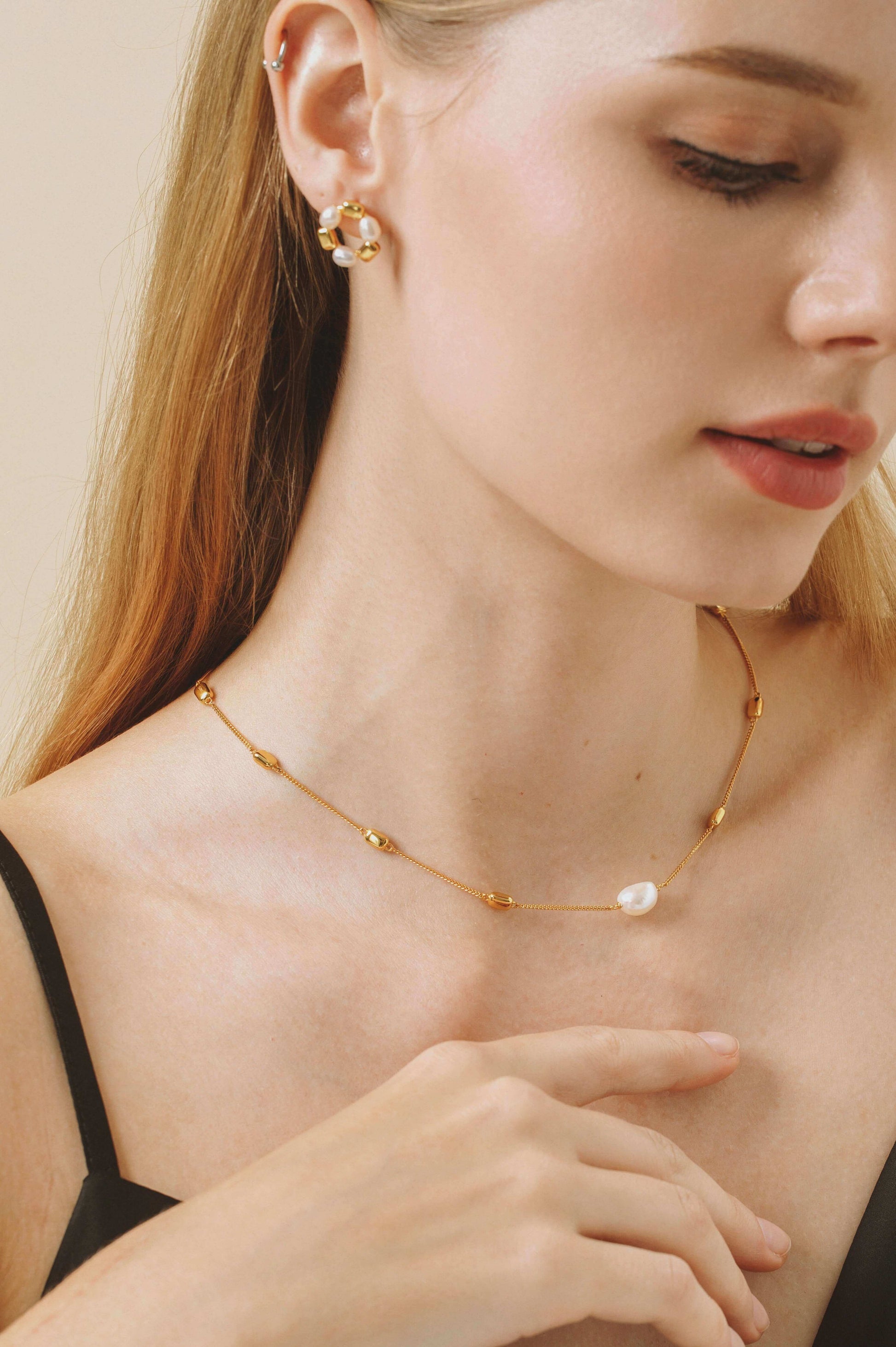 Woman wearing SUIHE Jewelry's "Jellybean" Necklace with gold vermeil, freshwater pearls, elegant styling, adjustable chain.