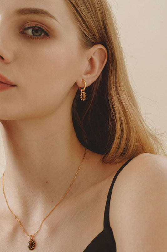 Model wearing "Mocha" Pendant Earrings by SUIHE Jewelry, featuring 18k gold-plated silver with yellow enamel and tiger's eye stones.