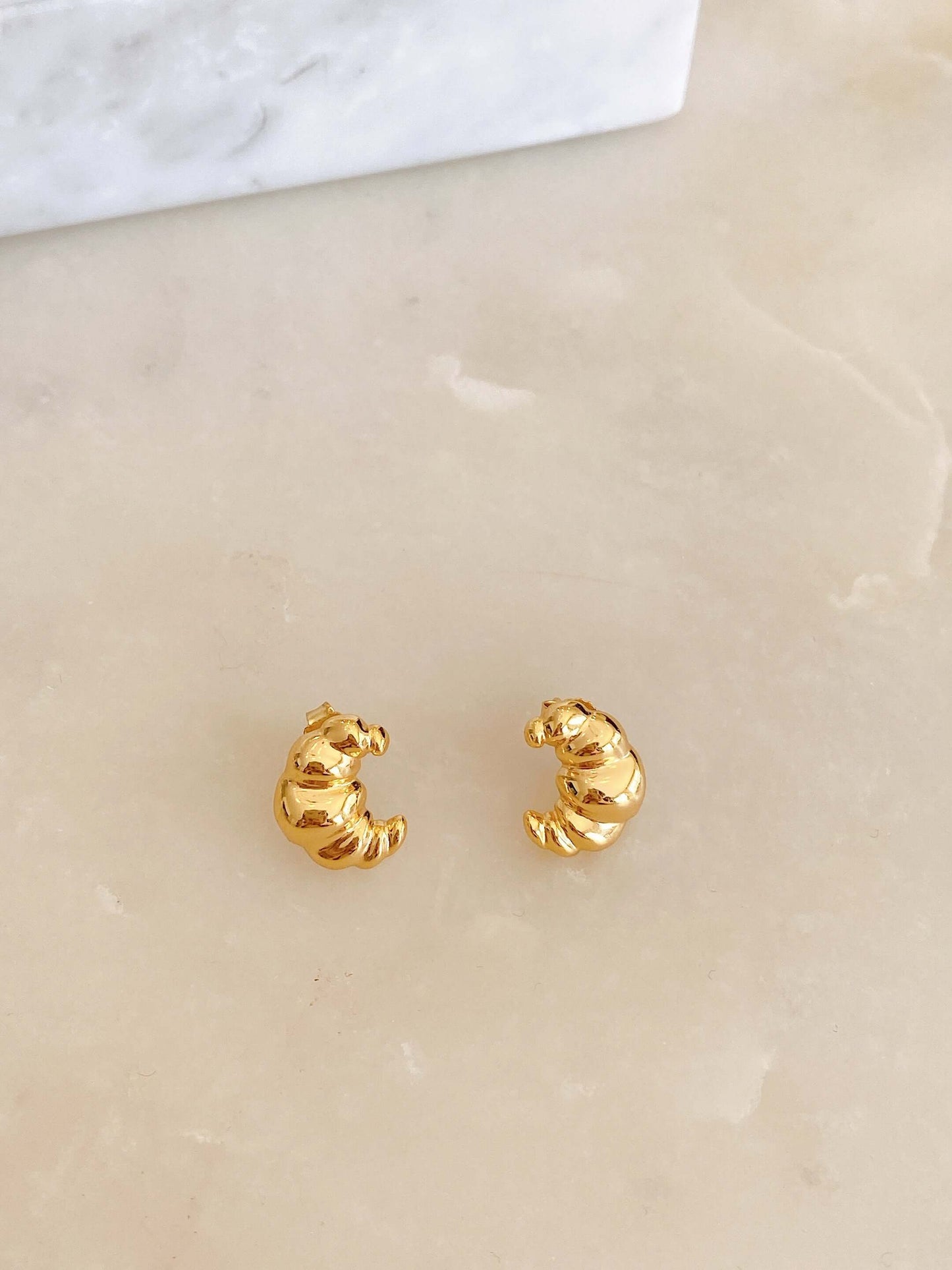 Elegant SUIHE Jewelry gold vermeil Croissant Stud Earrings, exuding Parisian elegance and charm, set on a light marble background.