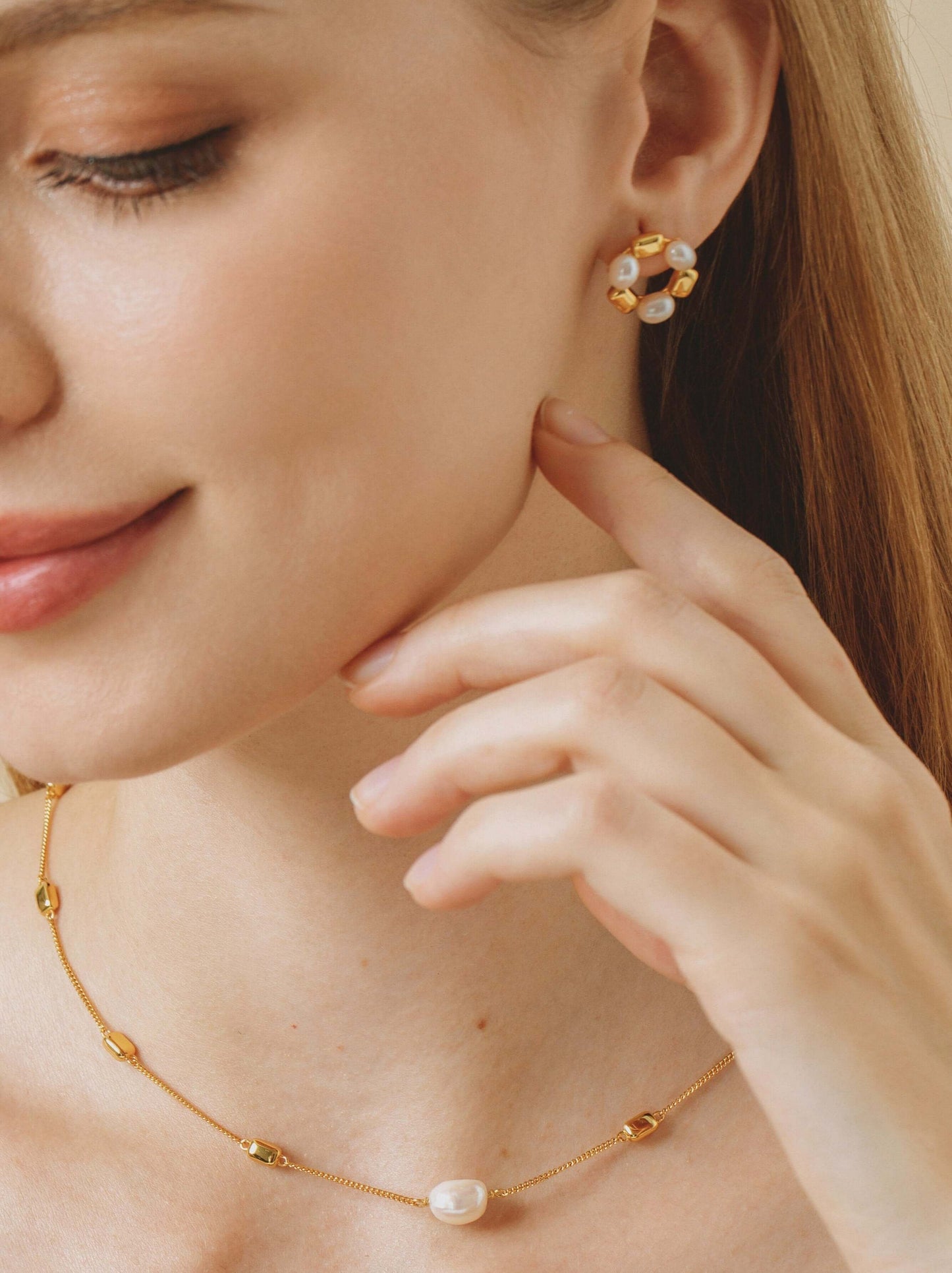 Woman wearing SUIHE Jewelry Jellybean Pearl Hoop Earrings and necklace, featuring freshwater pearls and gold accents.