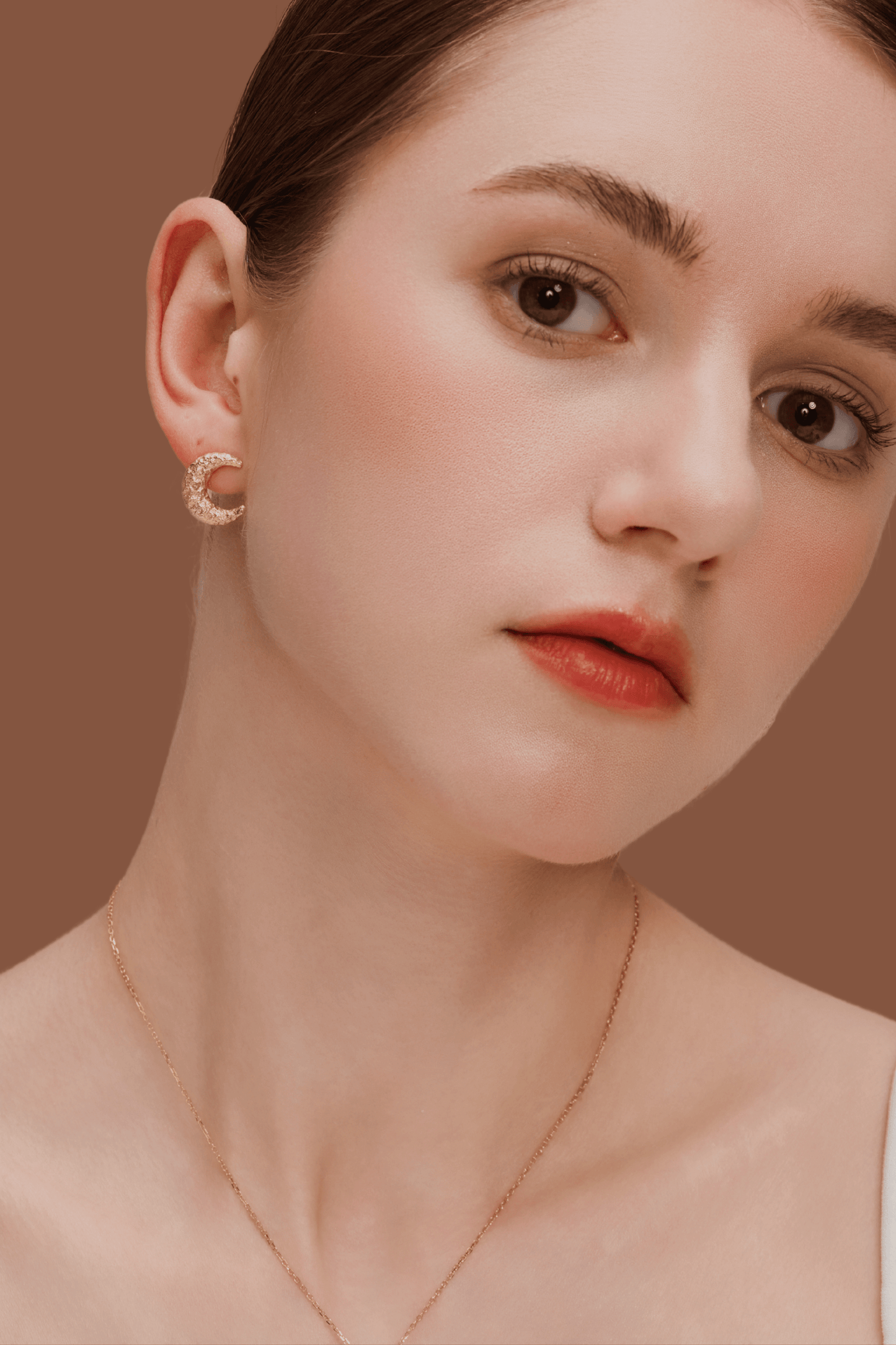 Woman wearing SUIHE Jewelry gold-plated Moon Earrings with textured crescent design against a neutral background.