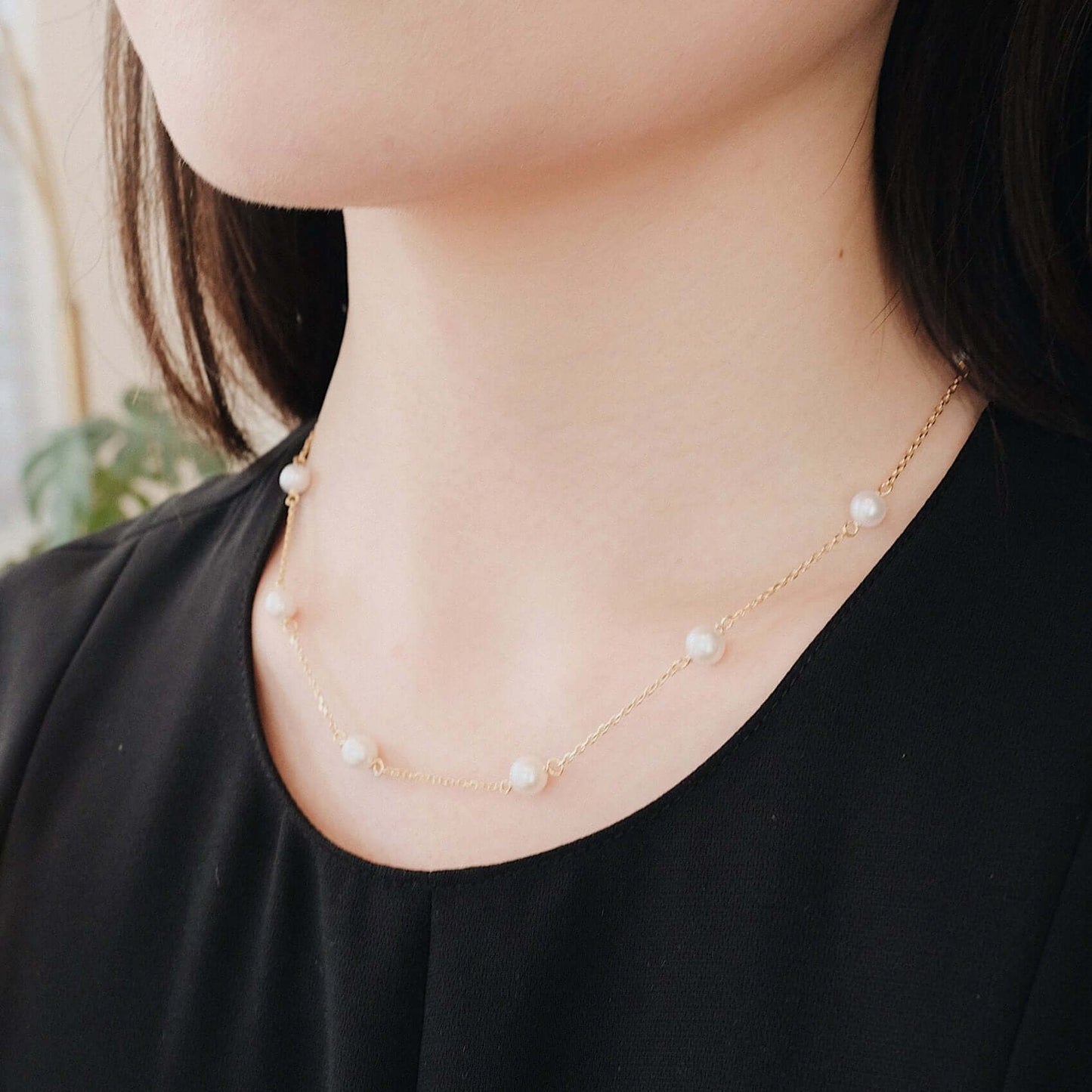 Woman wearing "Starry Night" Akoya Pearl Necklace by SUIHE Jewelry, featuring elegant pearls on a delicate chain.
