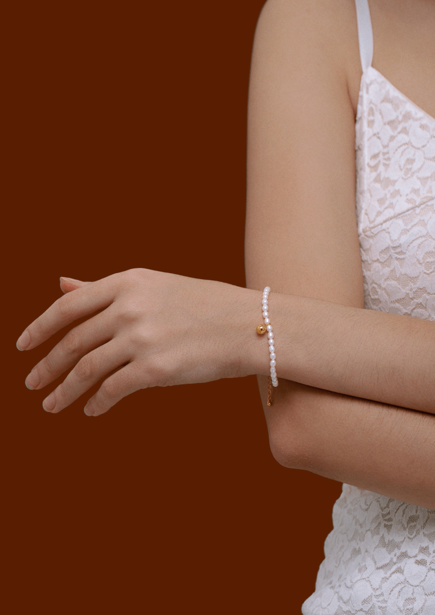 Model wearing Celestia freshwater pearl bracelet by SUIHE Jewelry with gold-tone bead charm, highlighting elegance and style.