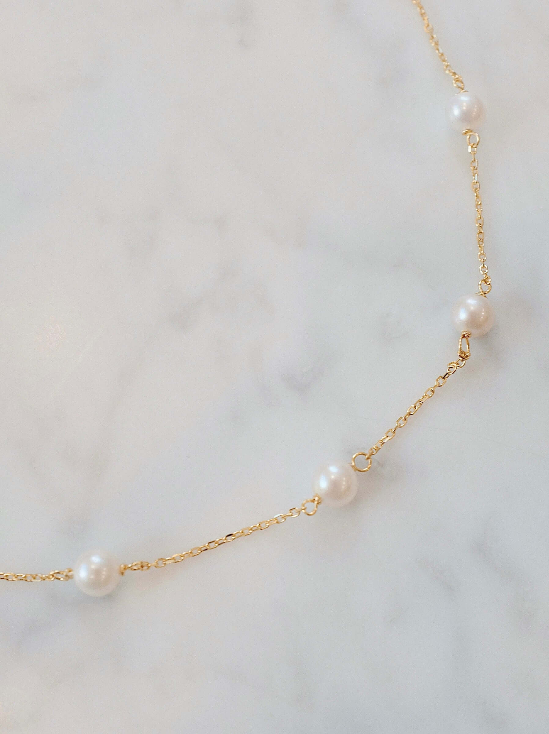 Delicate Akoya pearl necklace by SUIHE Jewelry, featuring lustrous pearls on a gold chain, capturing celestial elegance.