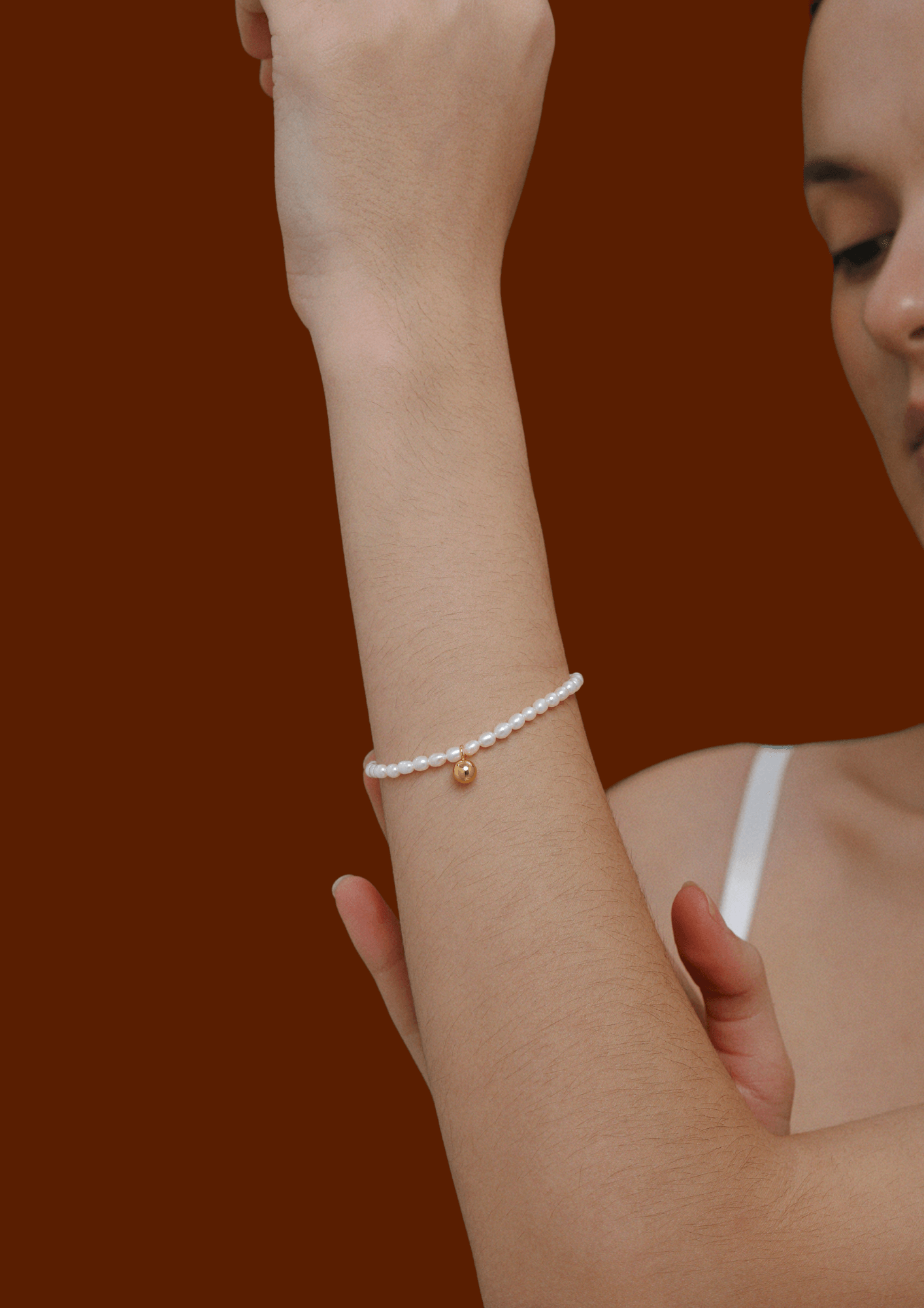 Celestia Freshwater Pearl Bracelet by SUIHE Jewelry on wrist, featuring gold-tone bead charm and adjustable clasp for elegant style.