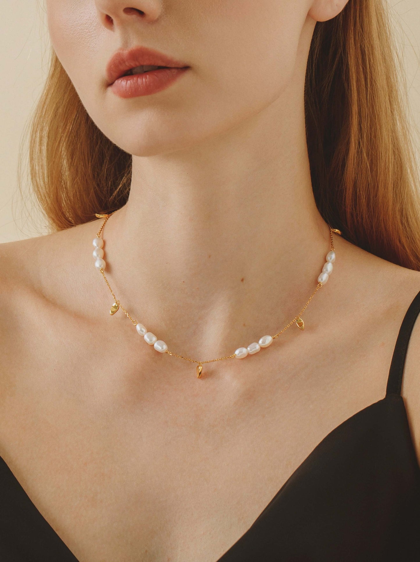 Woman wearing Candybean pearl necklace with irregular 5-6mm pearls on gold-plated chain by SUIHE Jewelry.
