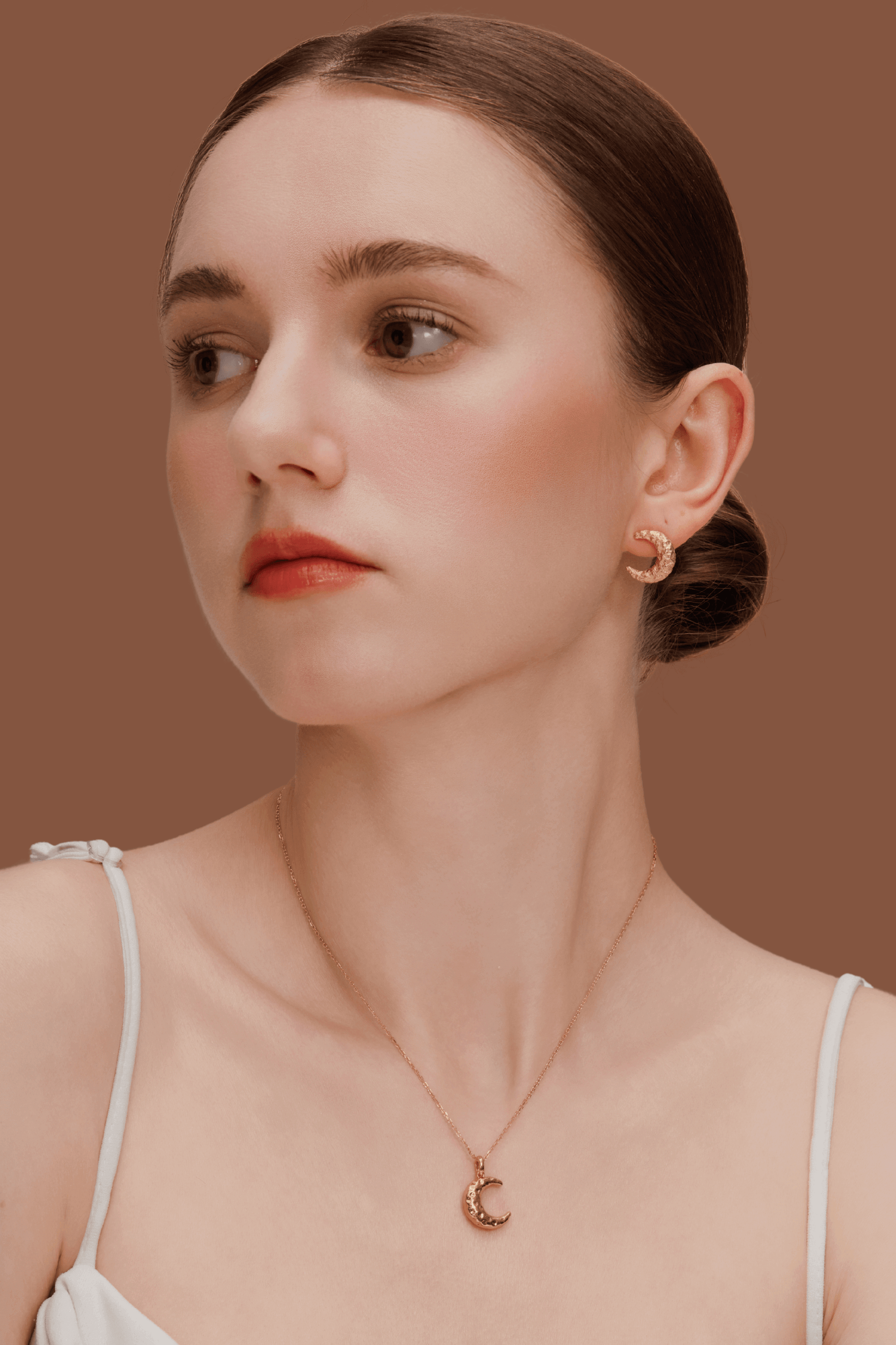 Woman wearing SUIHE Jewelry "Moon" Necklace crafted in gold, featuring a crescent moon pendant, styled with matching earrings.