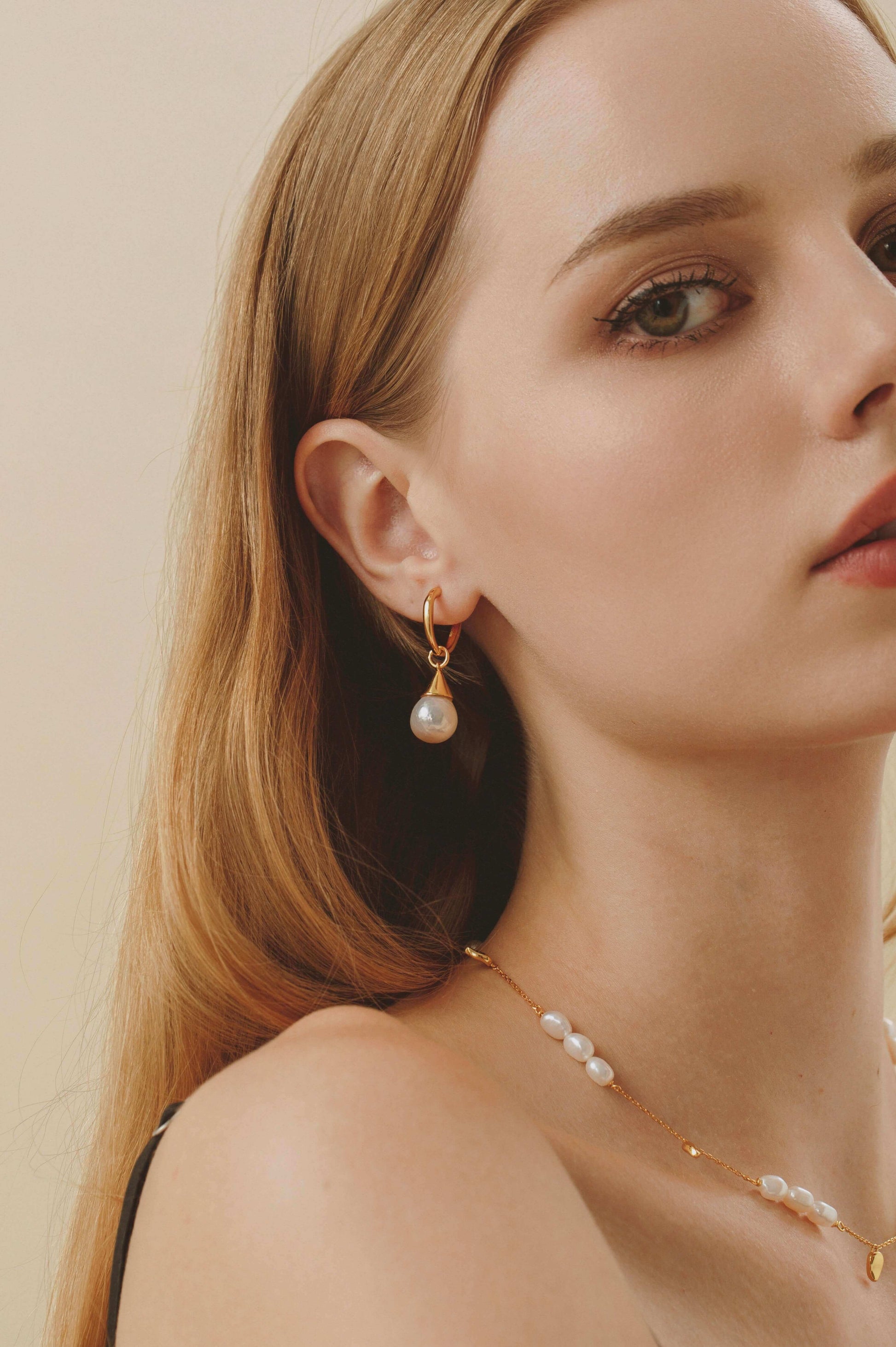 Woman wearing SUIHE Jewelry 'Candybean' pearl necklace with gold-plated chain, showcasing unique irregular pearls for refined elegance.