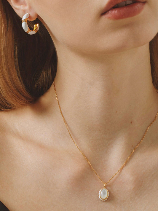 Woman wearing SUIHE Jewelry 'Luna' Mother-of-pearl Necklace with gold chain, highlighting the elegant pendant and matching earrings.