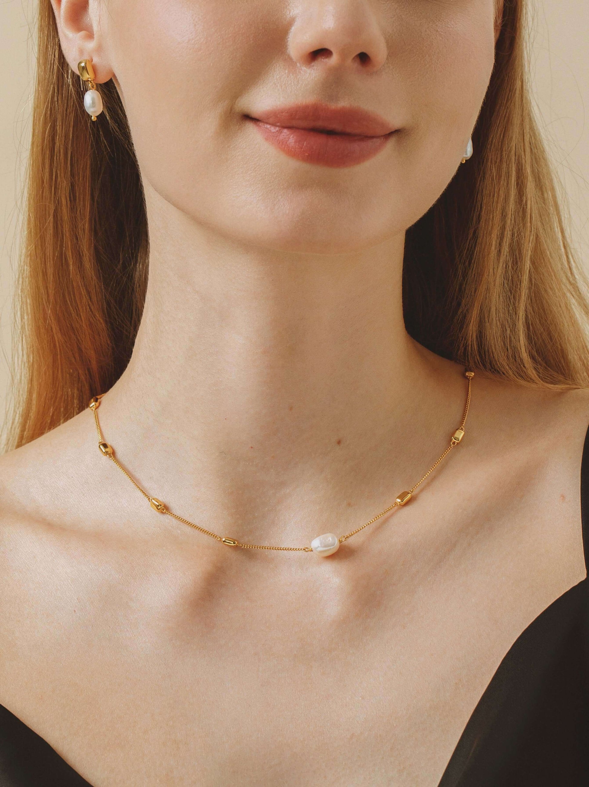Elegant model wearing 'Jellybean' Necklace by SUIHE Jewelry, featuring 18k gold vermeil and freshwater pearls, perfect for chic styling.