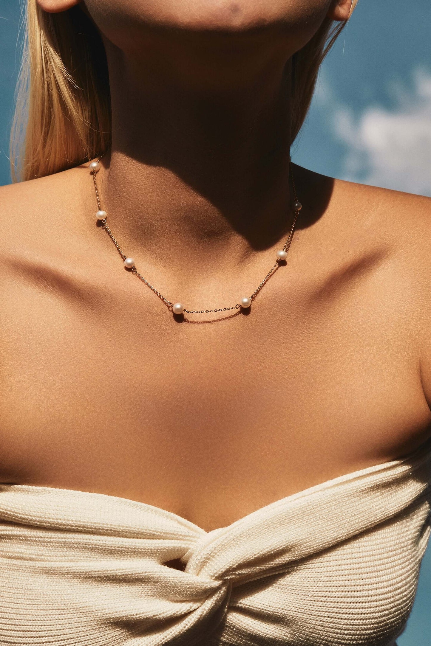 Elegant woman wearing "Starry Night" Akoya Pearl Necklace by SUIHE Jewelry in sunlight.