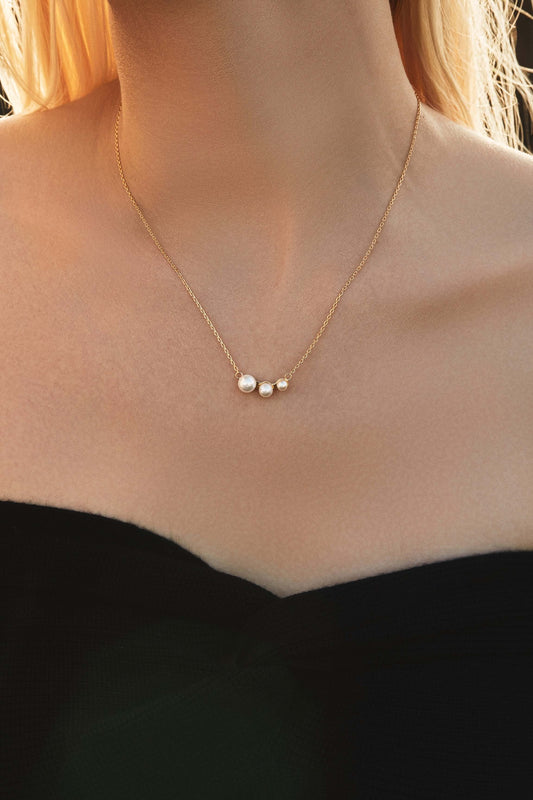 Woman wearing "Flare" freshwater pearl necklace by SUIHE Jewelry, featuring pearls on an 18k Gold Vermeil chain. Elegant and timeless design.