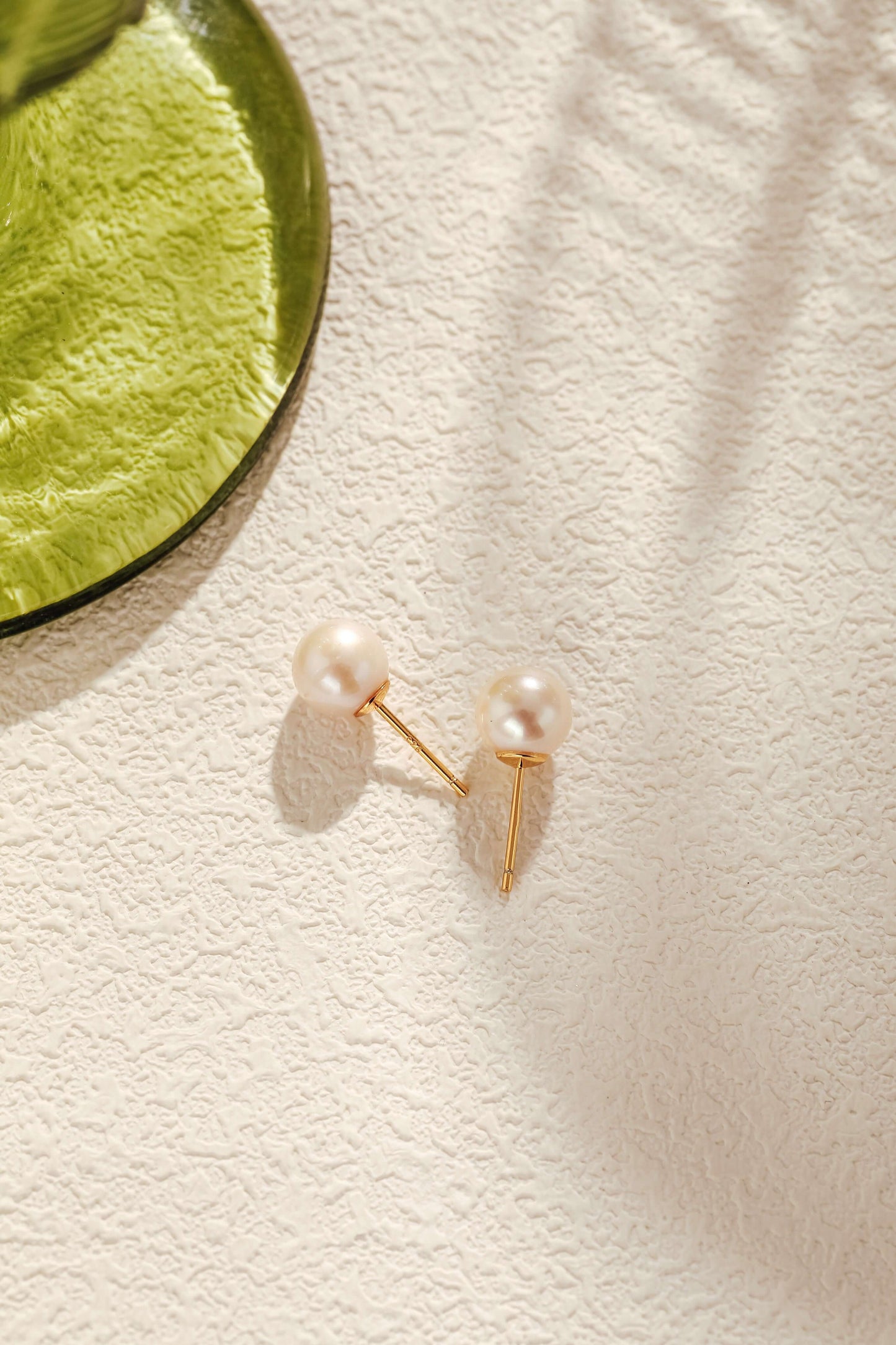 Aurora Akoya Pearl Stud Earrings in 18k gold vermeil by SUIHE Jewelry, elegantly resting on a textured surface