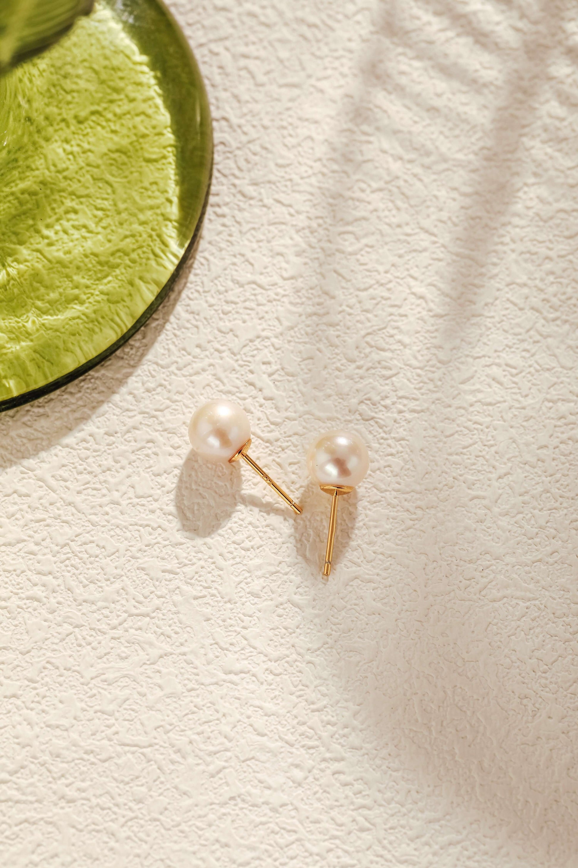 Aurora Akoya Pearl Stud Earrings in 18k gold vermeil by SUIHE Jewelry, elegantly resting on a textured surface