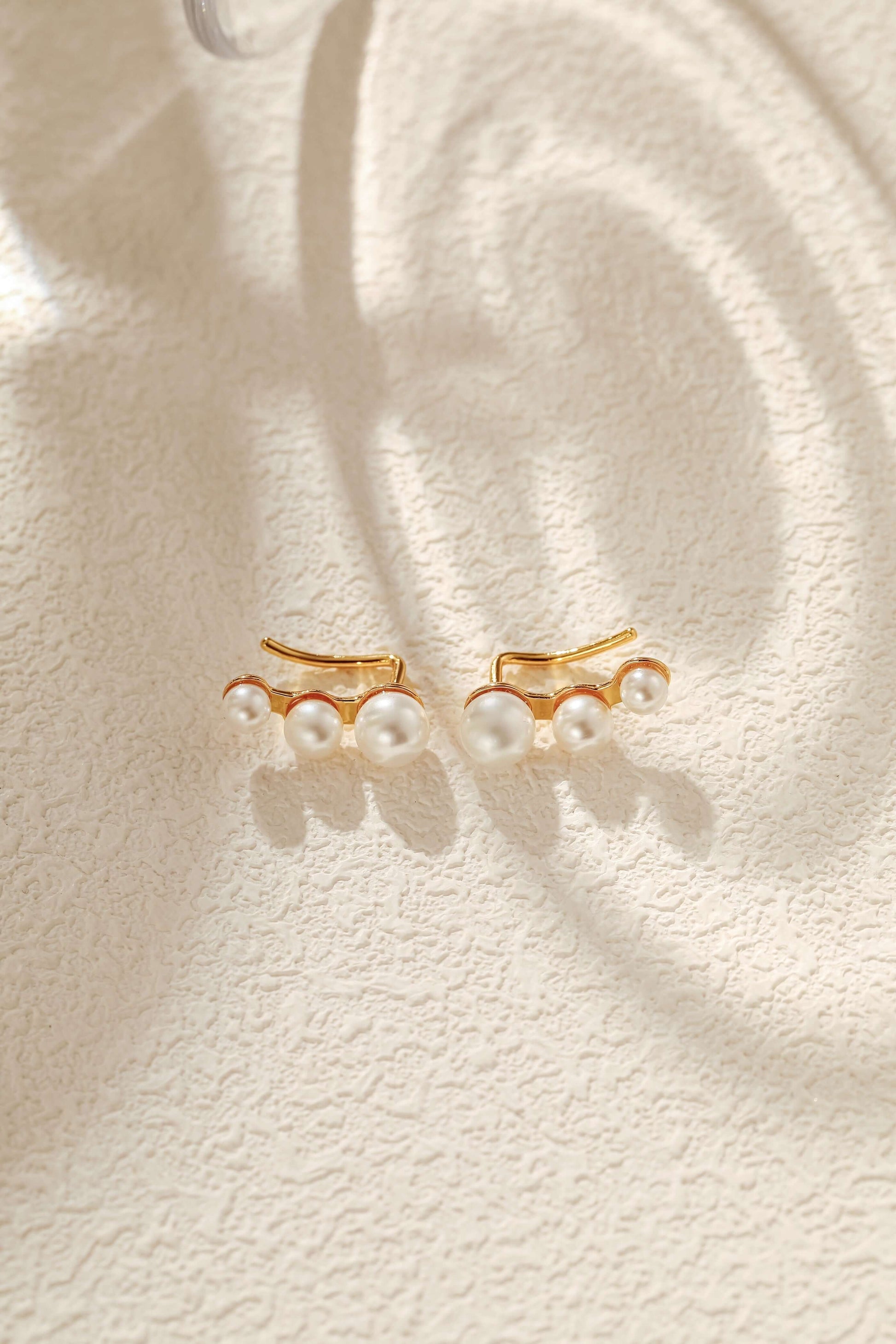 Flare Freshwater Pearl Earrings by SUIHE Jewelry in 18k Gold Vermeil, featuring timeless elegance and organic beauty on a textured surface.