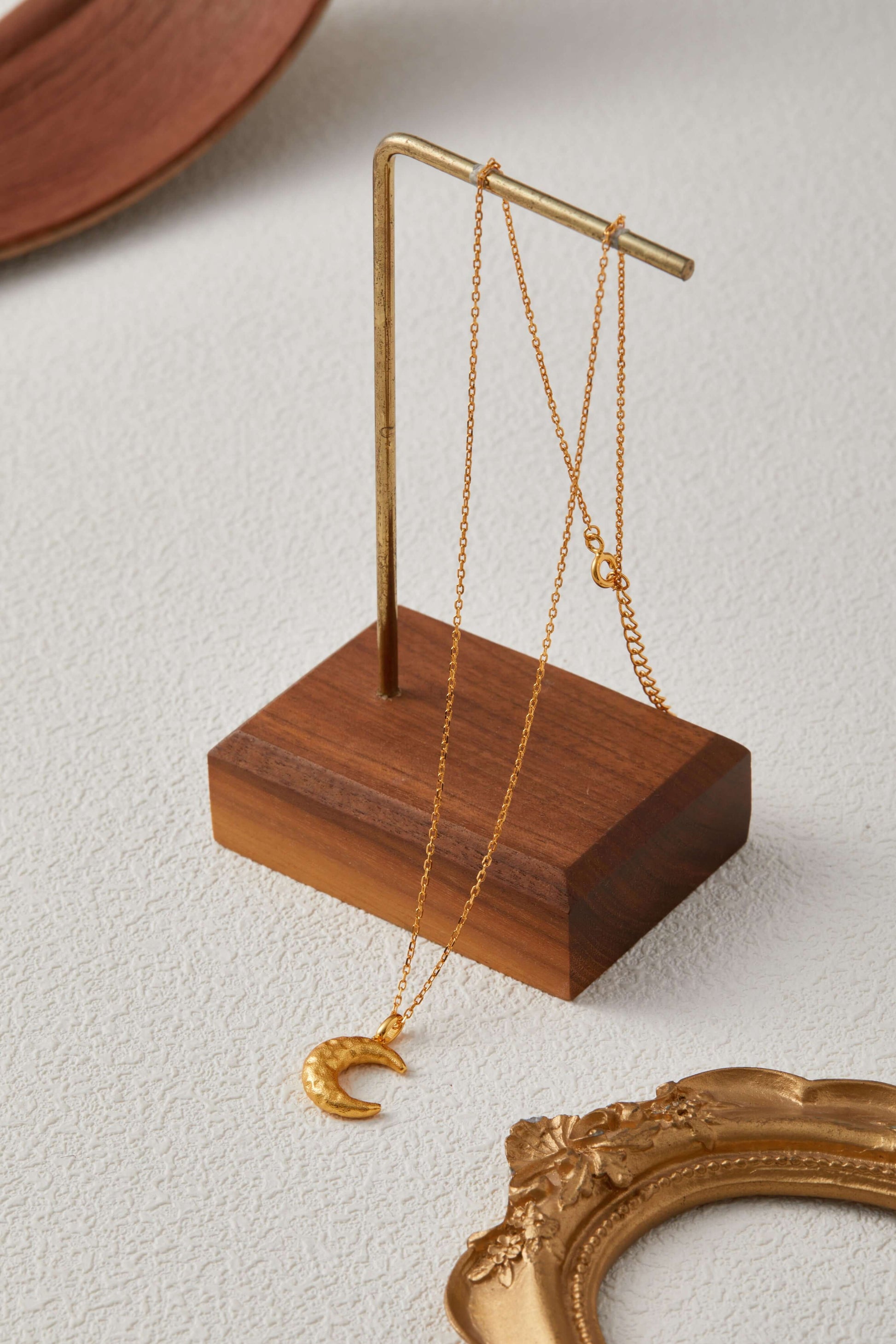 SUIHE Jewelry Moon Necklace with textured crescent pendant on a gold stand, showcasing celestial elegance and feminine energy.