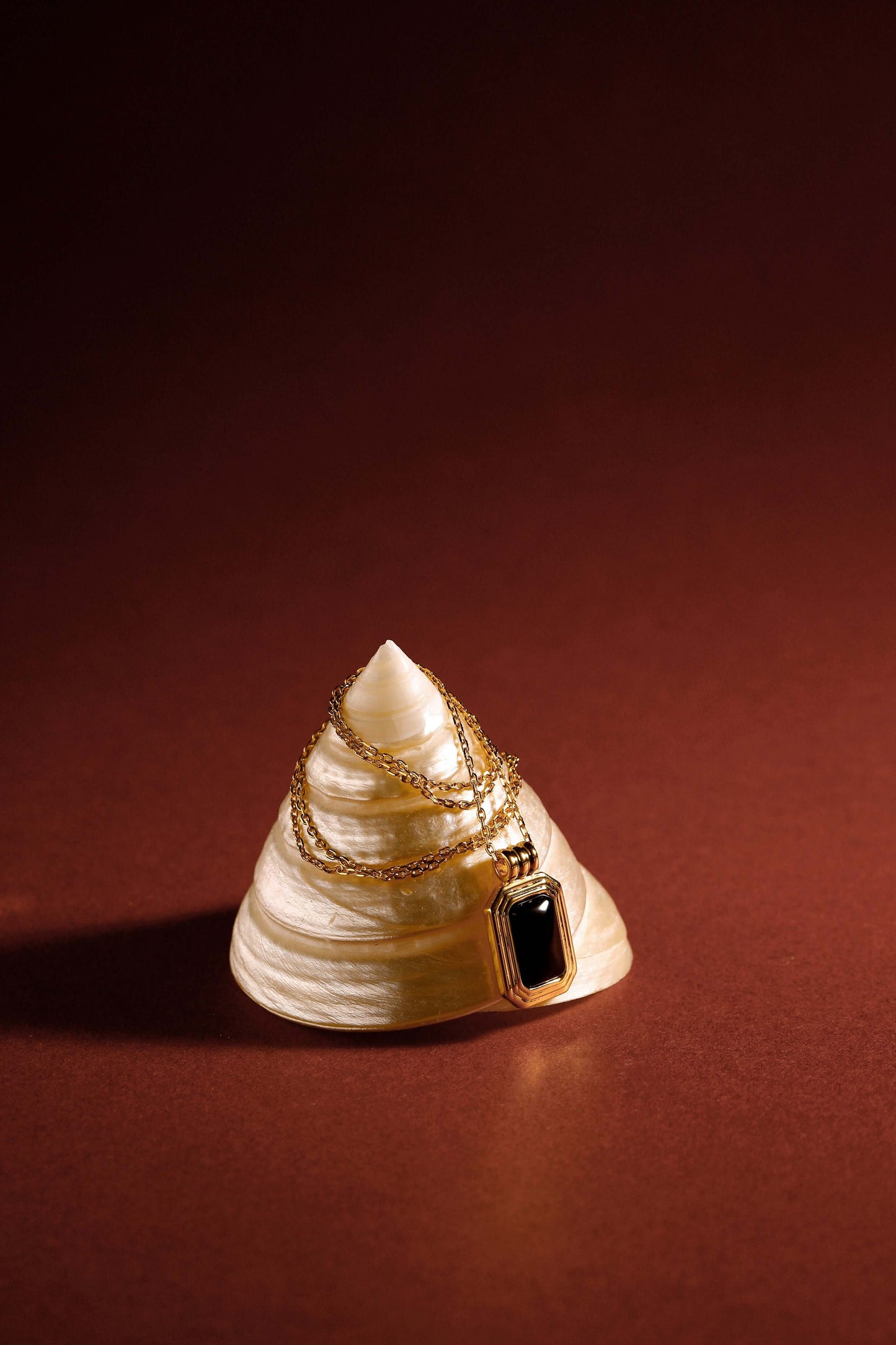 "Nocturne" Black Onyx Rectangle Necklace by SUIHE Jewelry on shell, set in 18k gold vermeil over sterling silver, symbolizes protection.