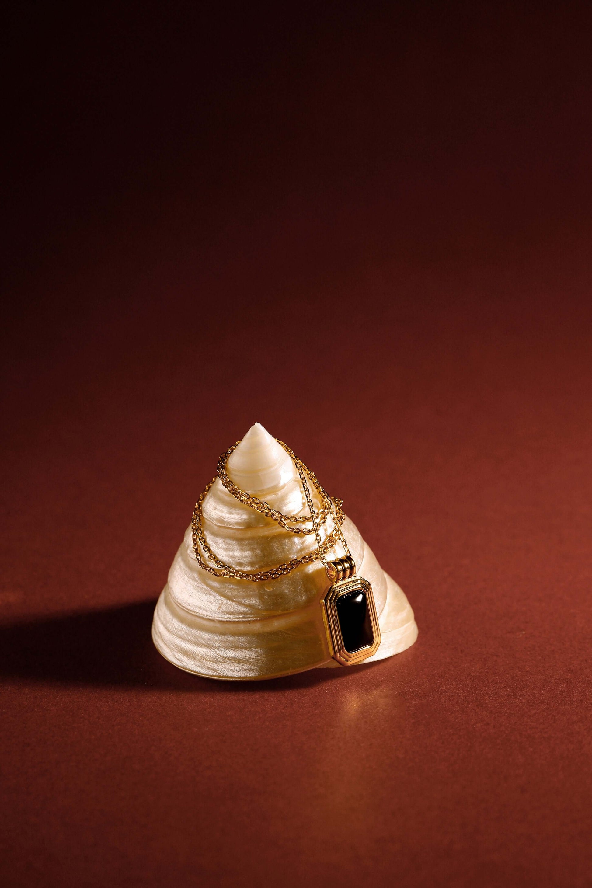 "Nocturne" Black Onyx Rectangle Necklace by SUIHE Jewelry on shell, set in 18k gold vermeil over sterling silver, symbolizes protection.