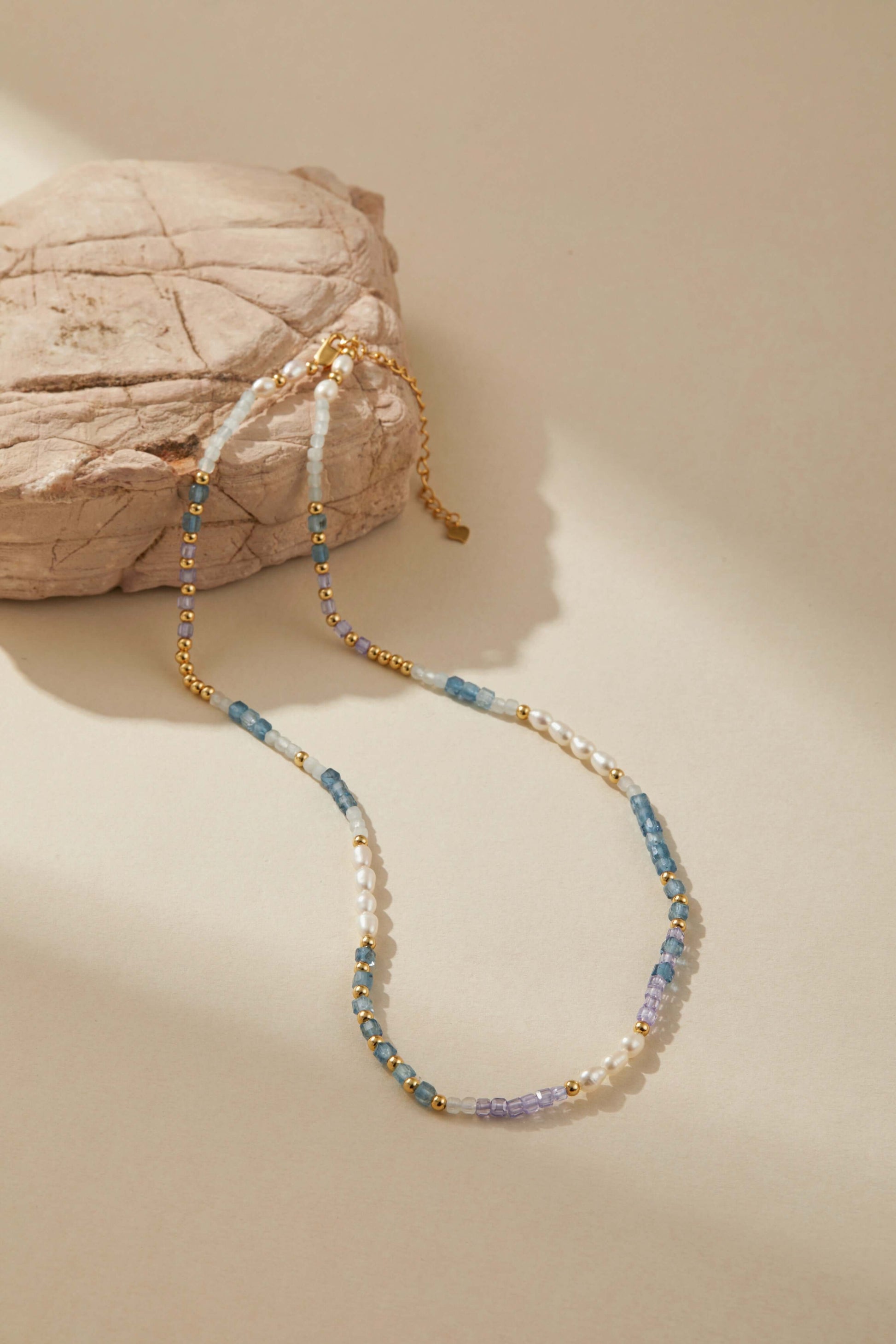 SUIHE Jewelry Ocean Natural Gemstone Necklace with pearls, blue and lavender stones on gold-plated beads, styled on a neutral background.