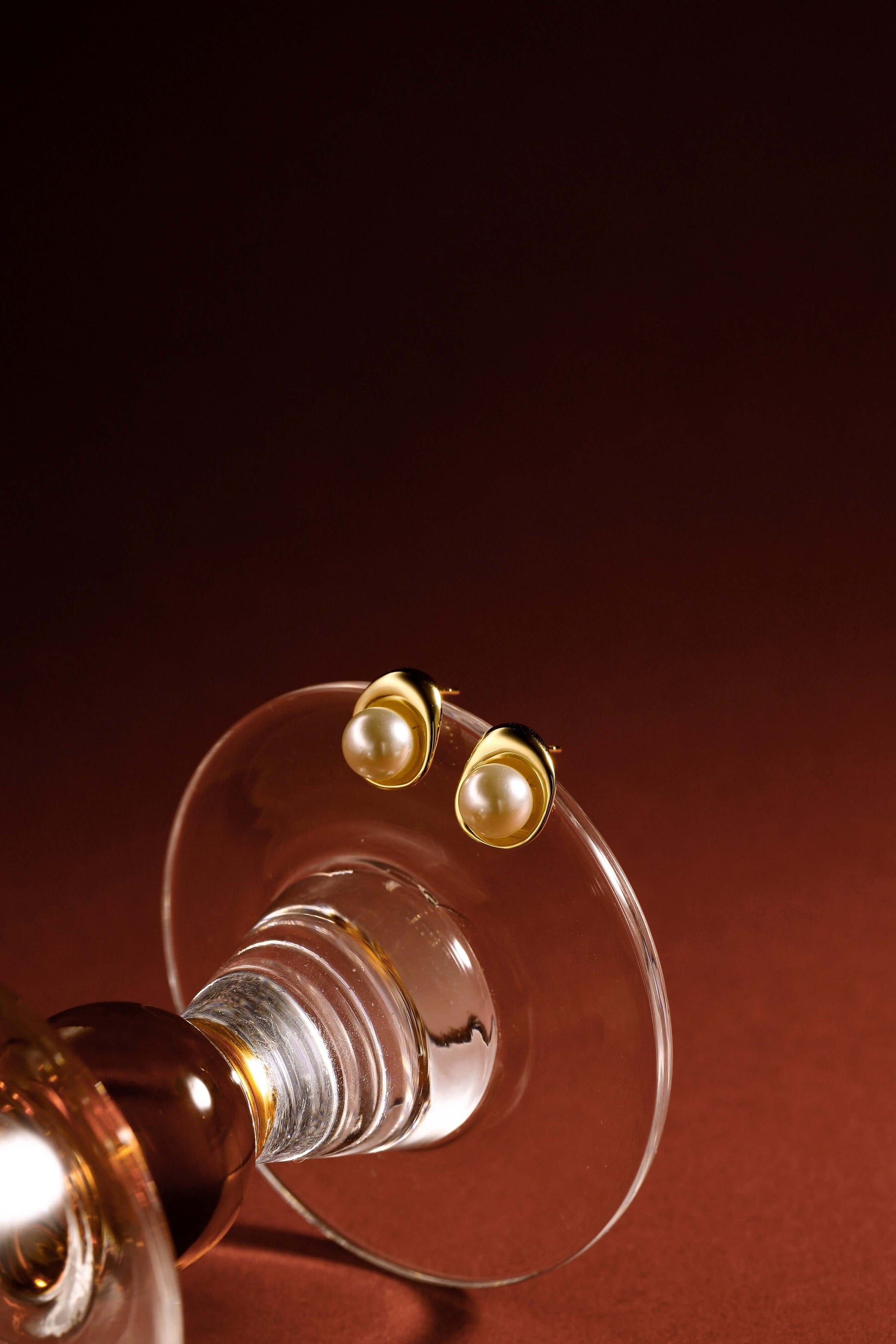 Elysian freshwater pearl stud earrings in 18k gold vermeil by SUIHE Jewelry displayed on a glass stand, exuding elegance.