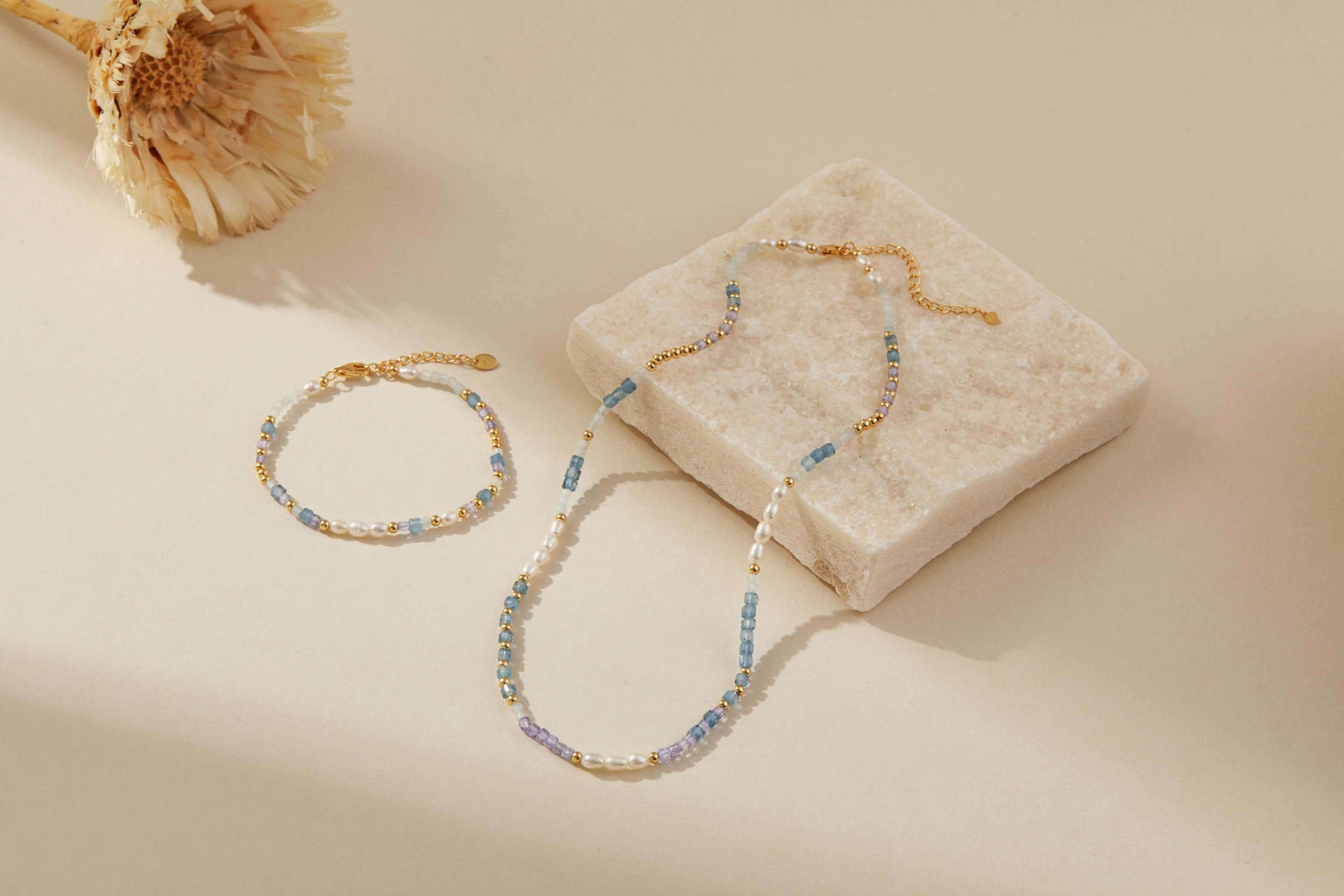 Ocean Natural Gemstone Necklace and bracelet set by SUIHE Jewelry featuring pearls, blue and lavender gemstones on a marble surface.