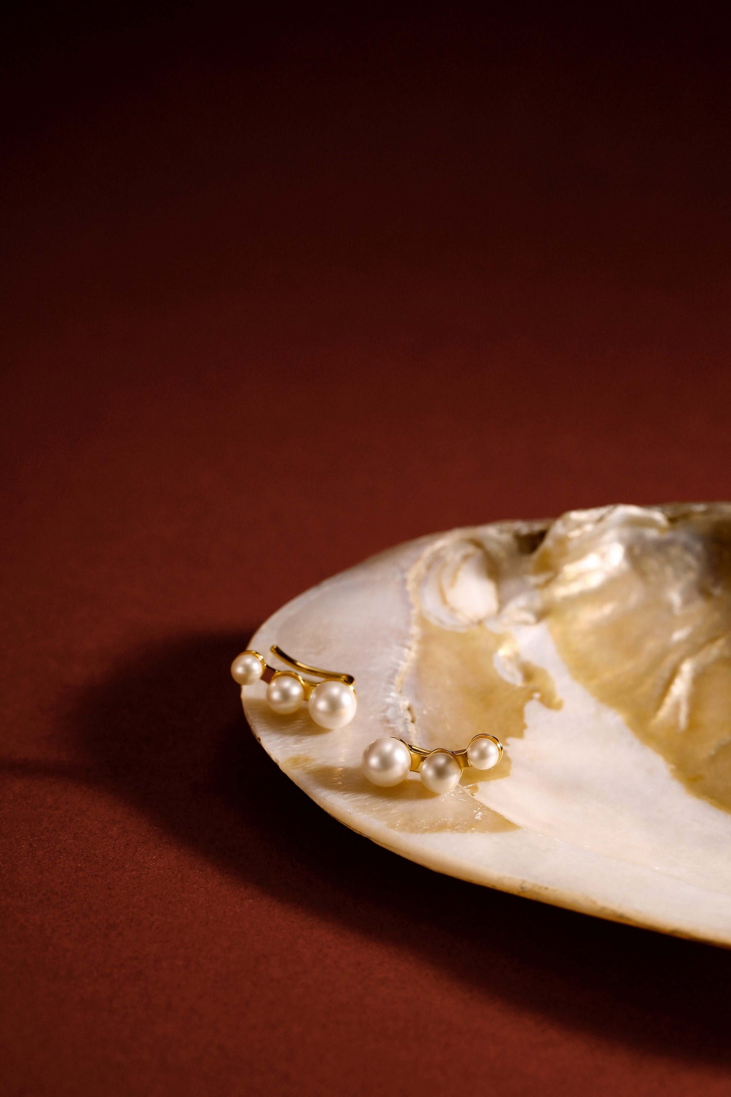 SUIHE Jewelry Flare Freshwater Pearl Earrings in 18k Gold Vermeil, elegant and timeless design on a rich background.