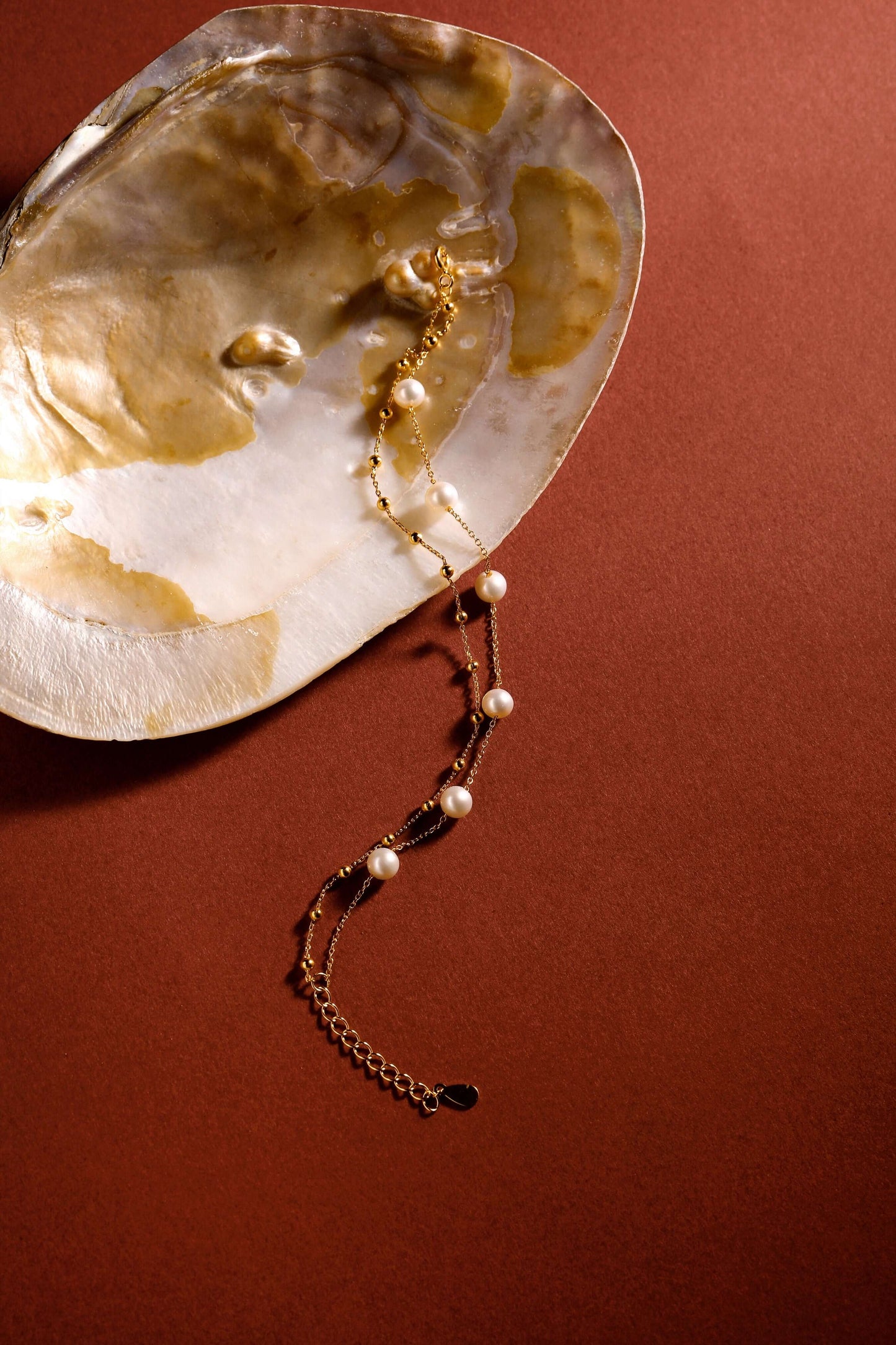 SUIHE Jewelry's Perfect Pearl Grace Bracelet in 18k Gold Vermeil with freshwater pearls, elegantly displayed on an open seashell.