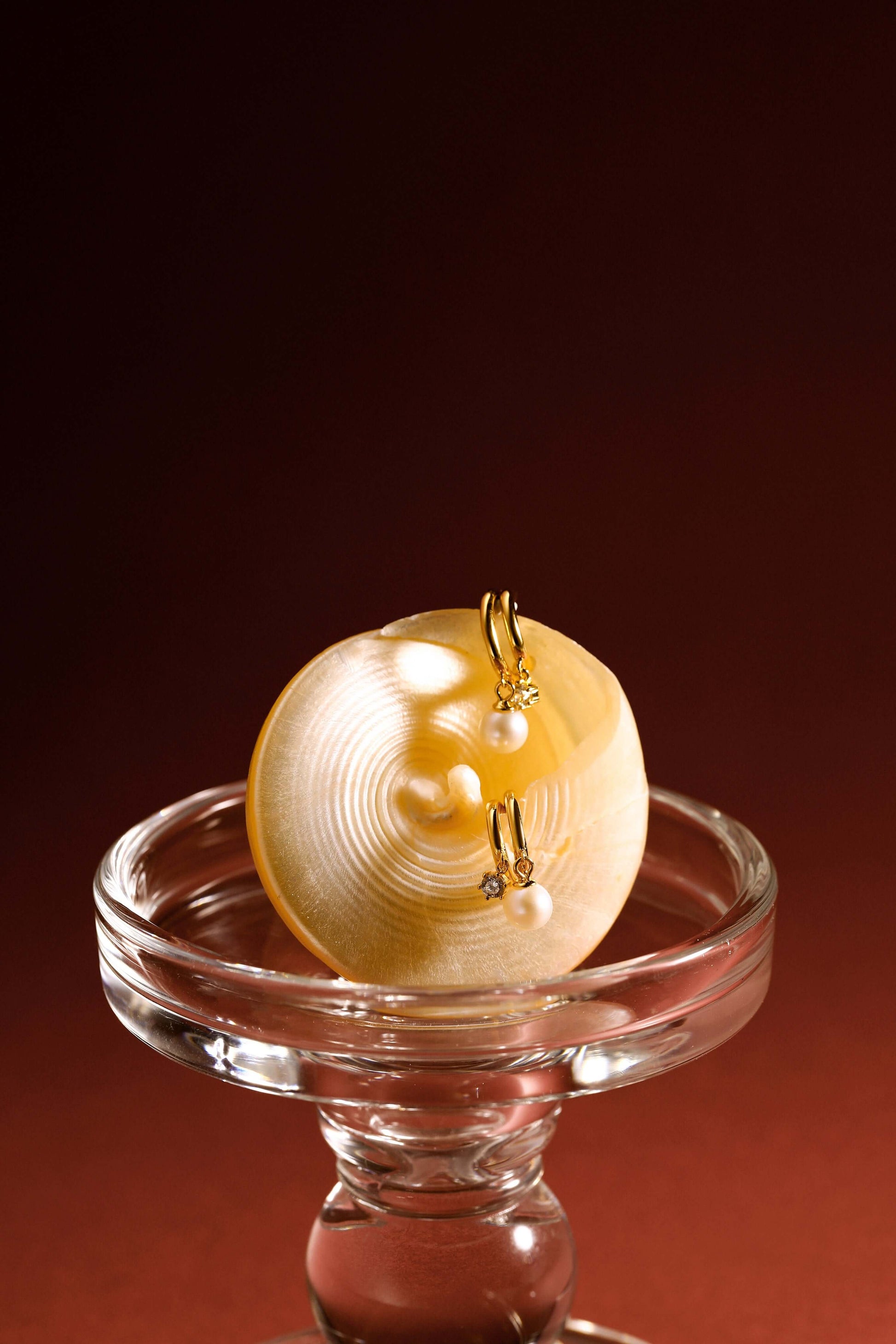 SUIHE Jewelry "Jellybean" Baroque Pearl Earrings on a glass stand, featuring 8-9mm irregular pearls and 18k gold vermeil.