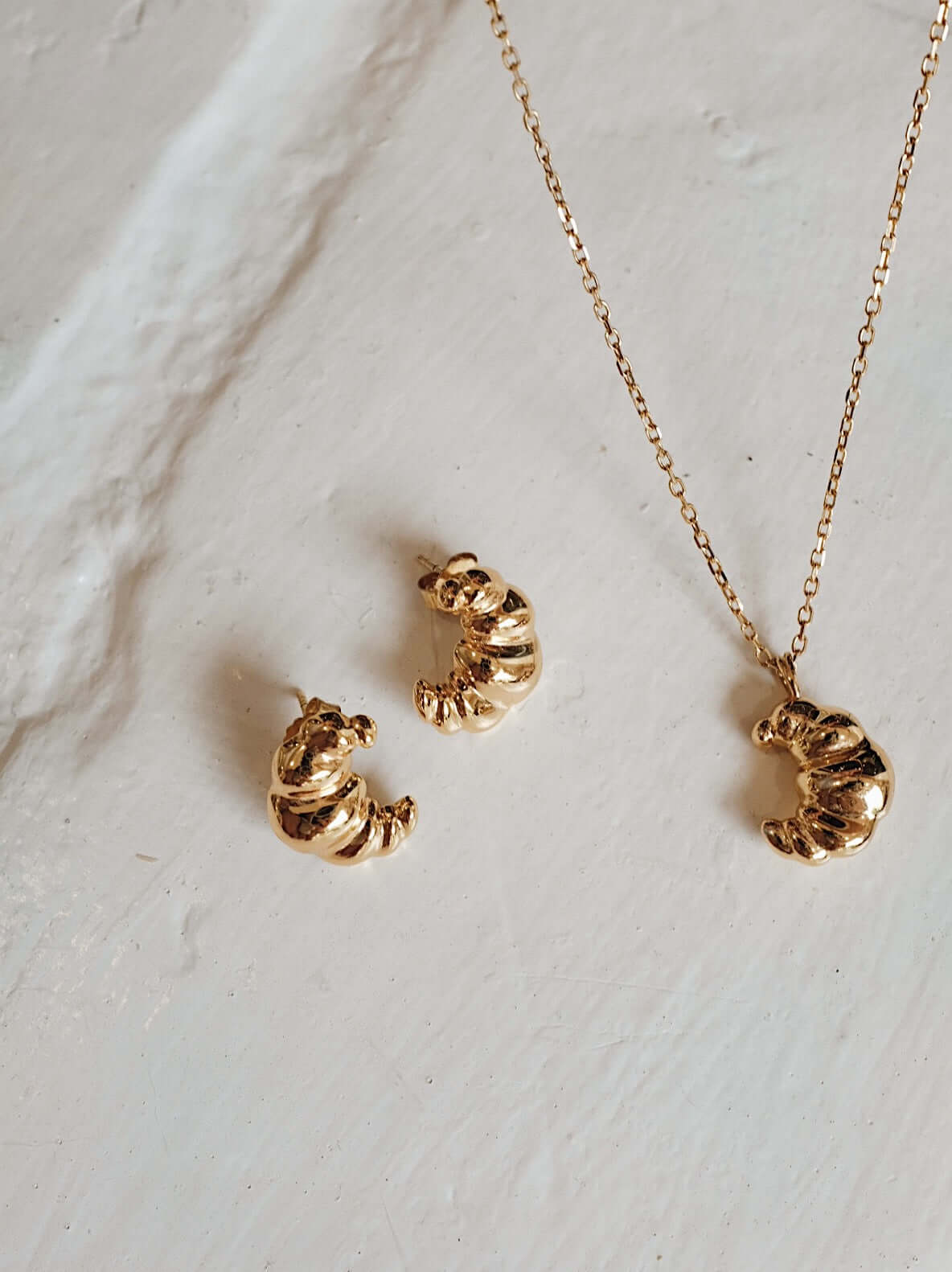 18k Gold Vermeil "Croissant" Necklace by SUIHE Jewelry, inspired by Parisian elegance, featuring a textured croissant charm on a chain.