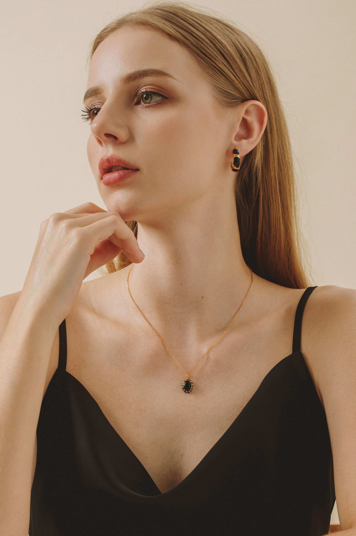 Model wearing Eclipse necklace featuring a black onyx pendant with black enamel on a gold vermeil chain by SUIHE Jewelry.