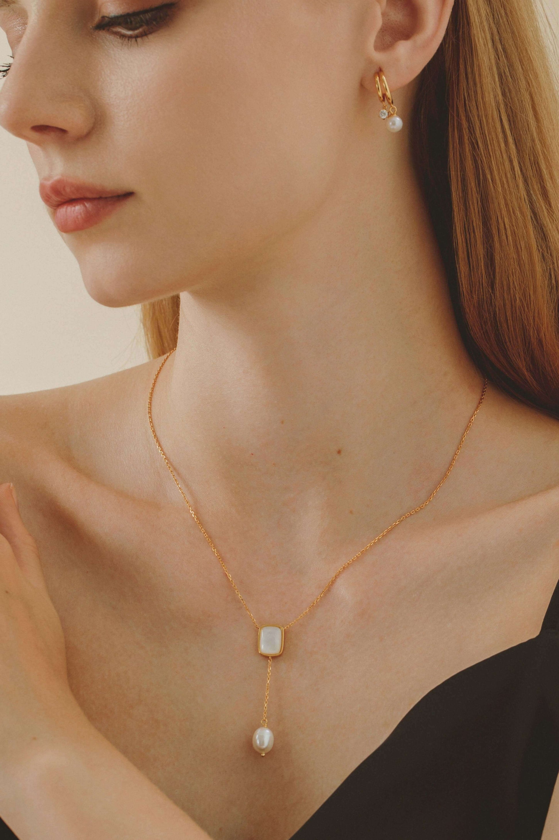 Woman wearing "Allure" Mother-Of-Pearl with Pearl Drop Necklace by SUIHE Jewelry, featuring a mother-of-pearl pendant and freshwater pearl.