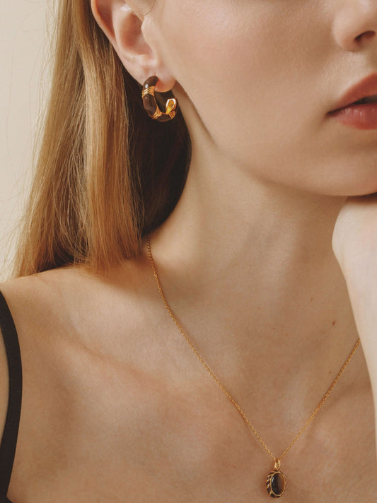 Woman wearing Mocha Hoop Earrings with gold vermeil and yellow enamel by SUIHE Jewelry, showcasing modern luxury and earthy tones.