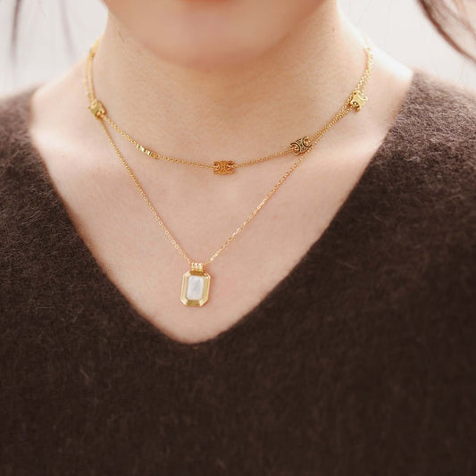Woman wearing a SUIHE Jewelry "Radiance" Mother-of-pearl rectangle necklace with 18k Gold Vermeil, showcasing elegance and serenity.