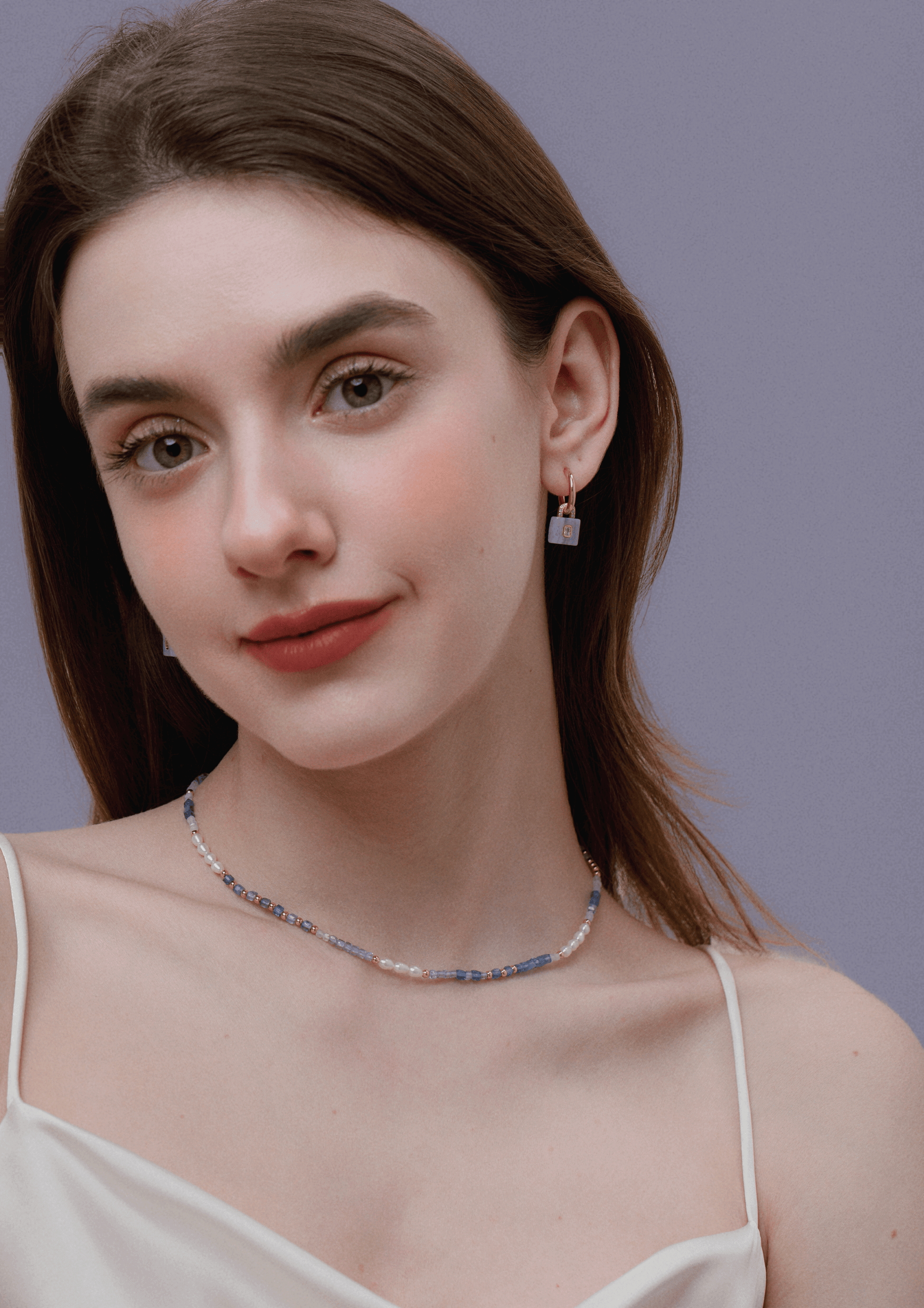 Woman wearing SUIHE Jewelry Ocean Natural Gemstone Necklace with pearls and blue, lavender gemstones.
