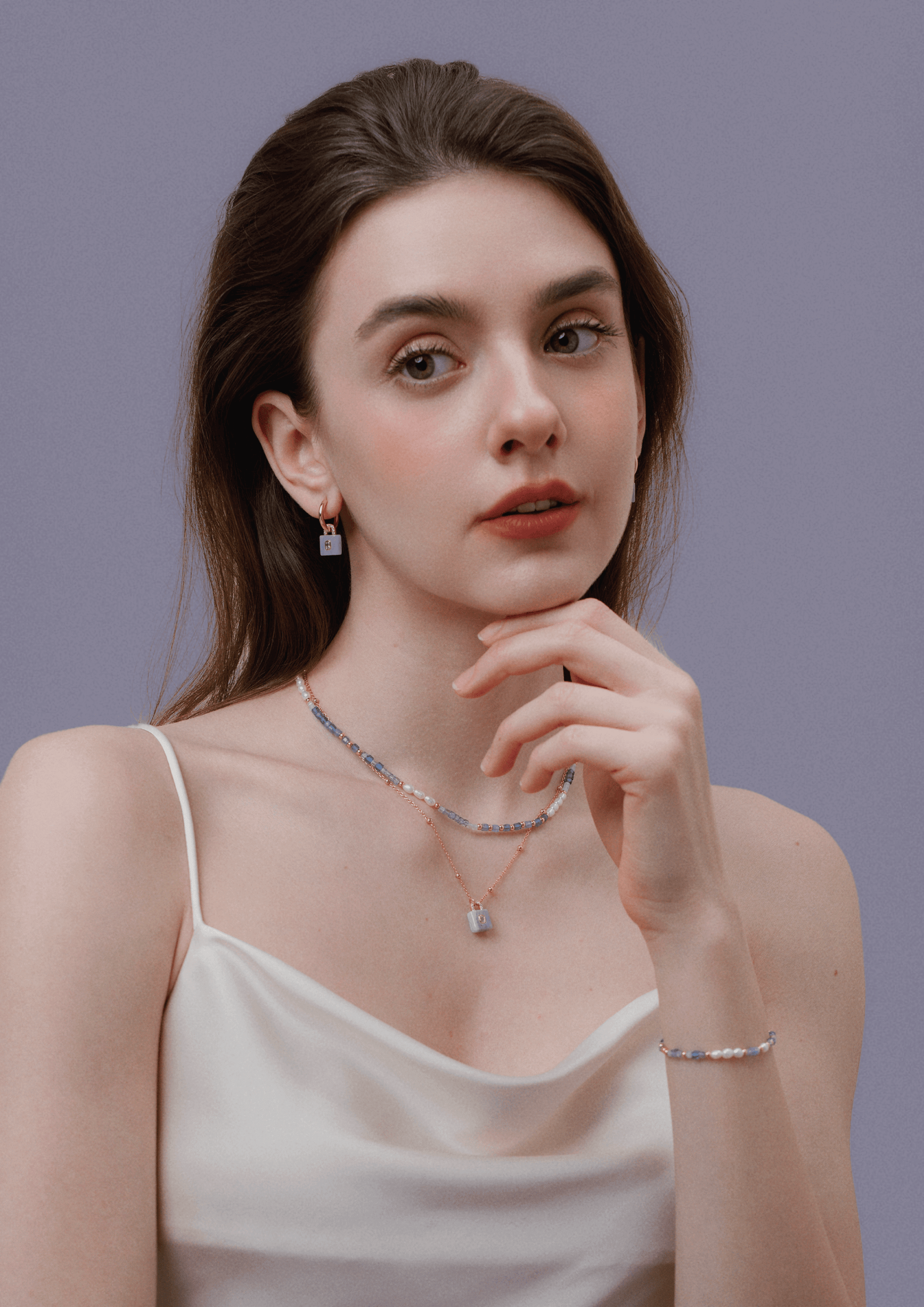 Woman wearing "Ocean" Natural Gemstone Necklace by SUIHE Jewelry with pearls and blue, lavender gemstones.