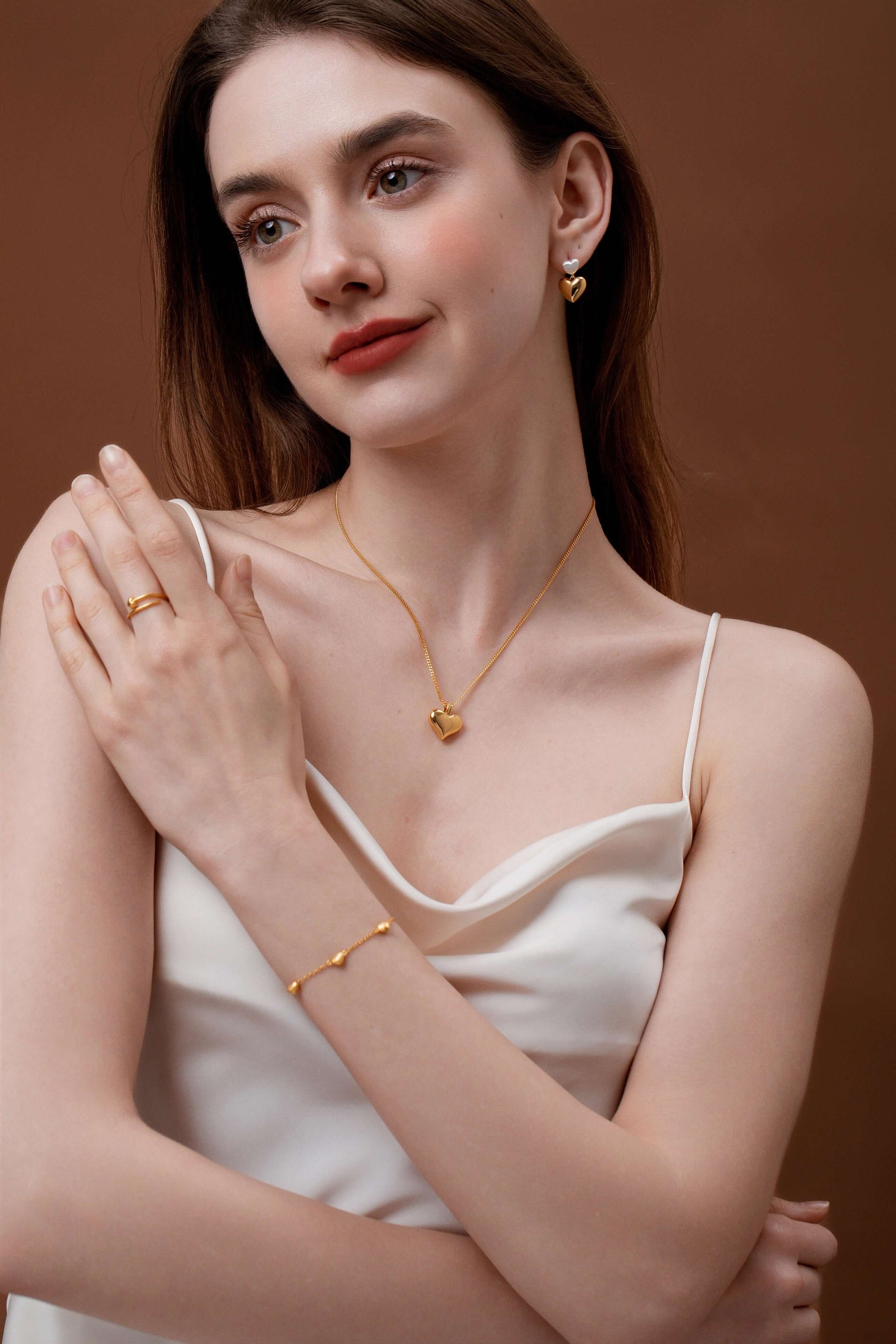 Woman wearing SUIHE Jewelry Amour Double Heart Earrings, showcasing the elegant silver and gold heart design against a stylish outfit.