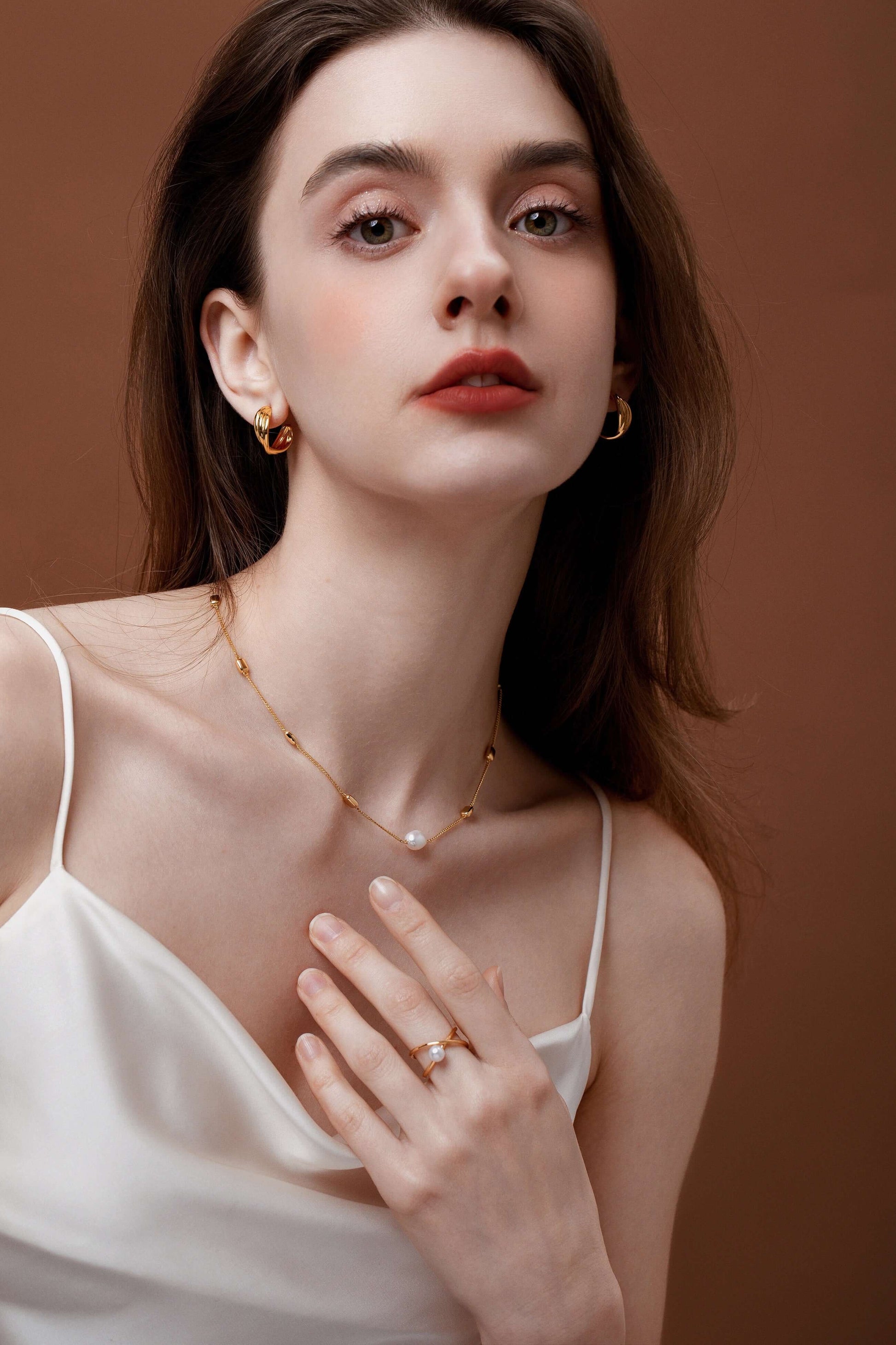 Woman wearing SUIHE Jewelry Wavelet Freshwater Pearl Ring and gold necklace, showcasing elegance and modern design.