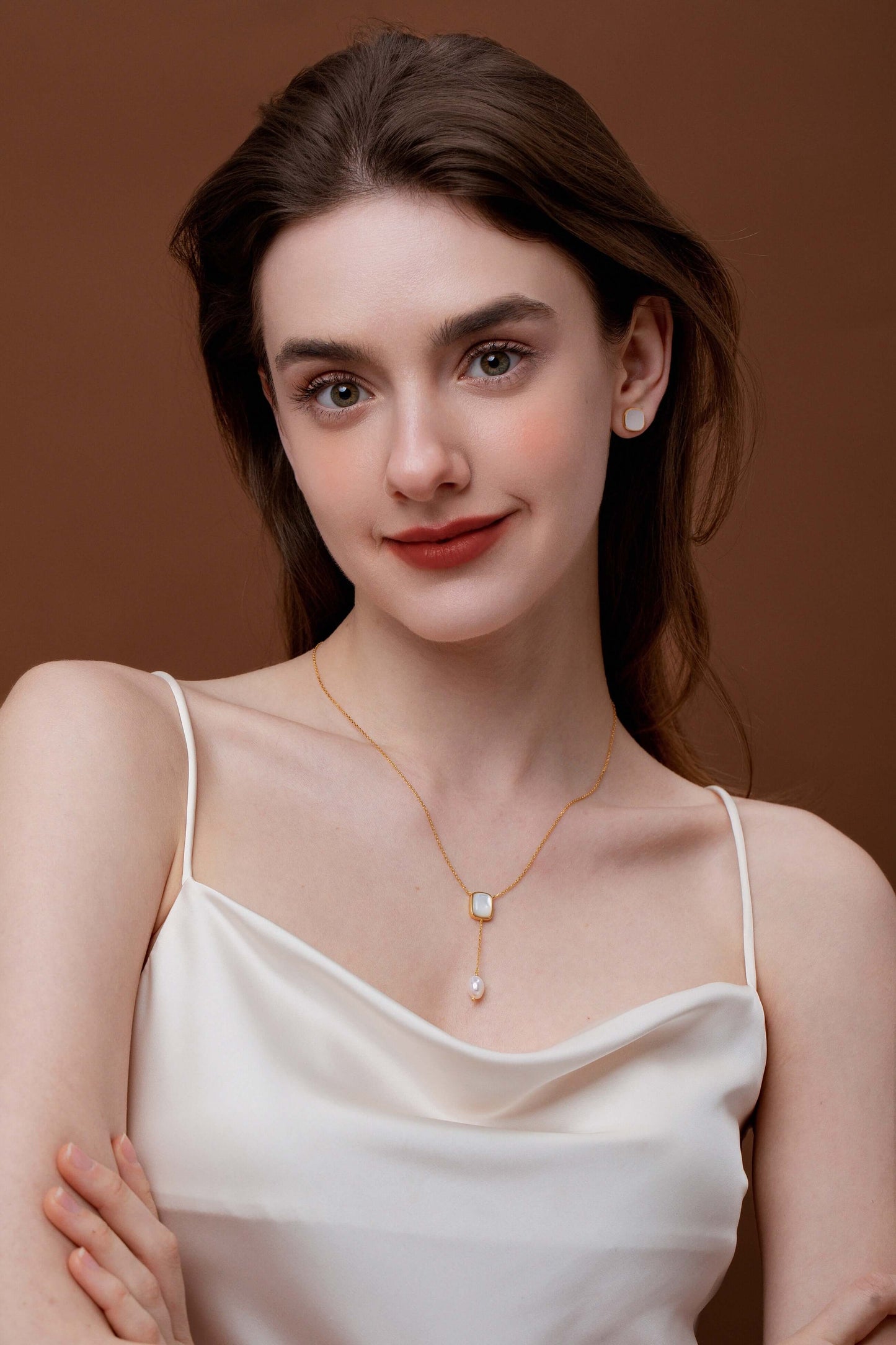 Elegant woman wearing SUIHE Jewelry 'Allure' Mother-Of-Pearl and Pearl Drop Necklace with adjustable chain, perfect for layering.
