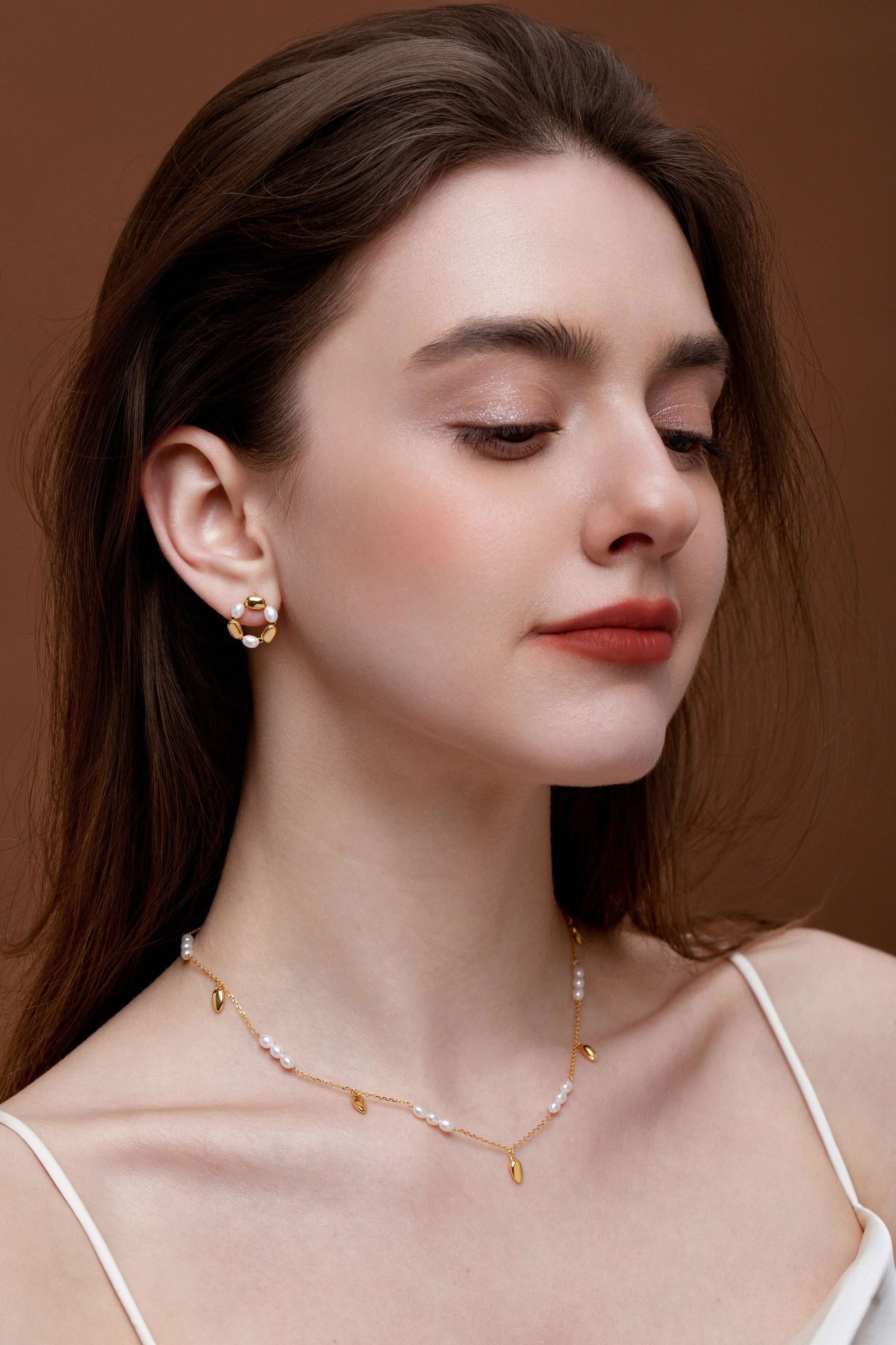 Woman wearing SUIHE Jewelry "Candybean" Pearl Necklace with gold-plated chain, showcasing elegance and versatility.