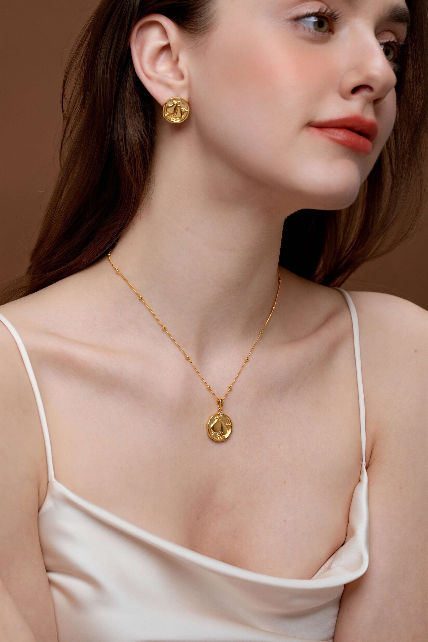 Woman wearing SUIHE Jewelry gold pear necklace and earrings set, showcasing elegance and simplicity with intricate detailing.