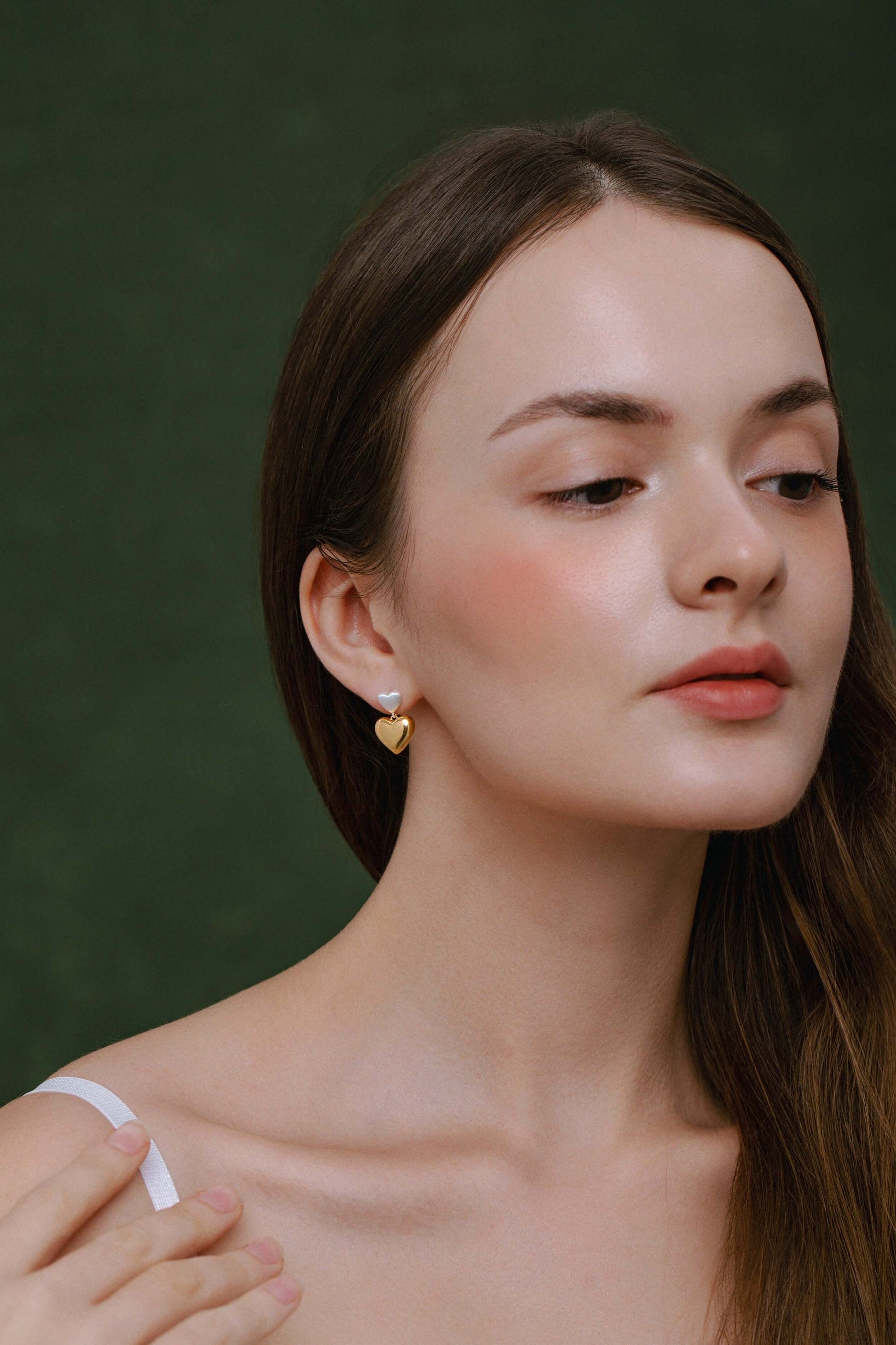 Model wearing SUIHE Jewelry Amour Double Heart Earrings in silver and gold with dual-heart design.