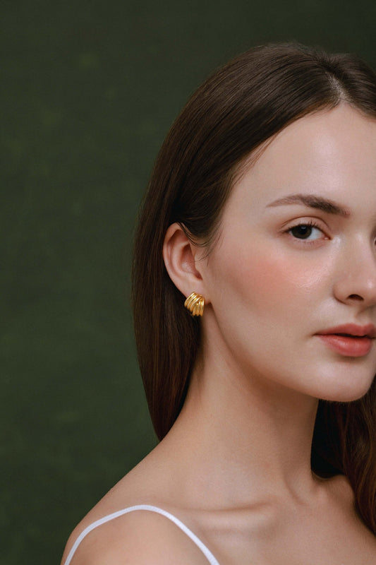 Model wearing SUIHE Jewelry's Wave Earrings, gold-plated with sculptural curves, showcasing modern artistry and timeless elegance.