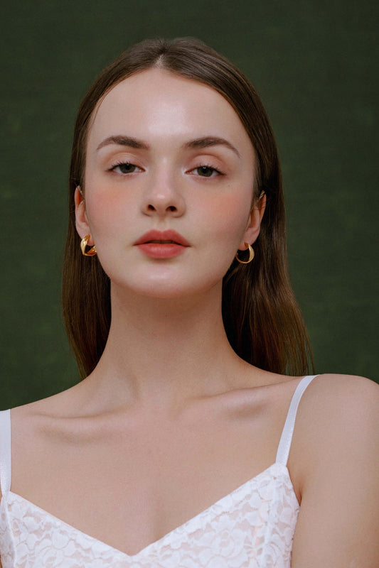 Model wearing Wavelet Hoop Earrings by SUIHE Jewelry, featuring gold wave-inspired design, adding elegance to her look.