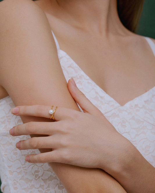 Woman wearing Wavelet Freshwater Pearl Ring by SUIHE Jewelry, featuring a pearl on a gold-tone wave-like band in a minimalistic design.
