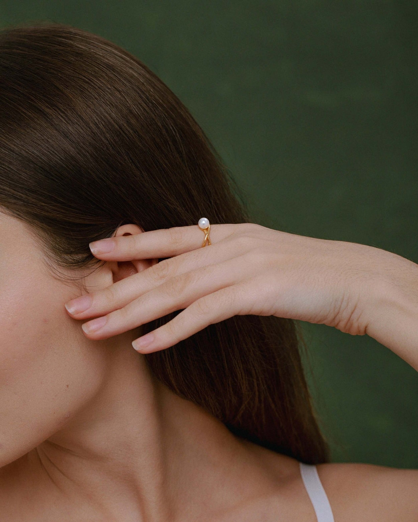 Woman wearing "Wavelet" Freshwater Pearl Ring by SUIHE Jewelry, featuring a pearl on a gold-tone wave band, showcasing modern elegance.