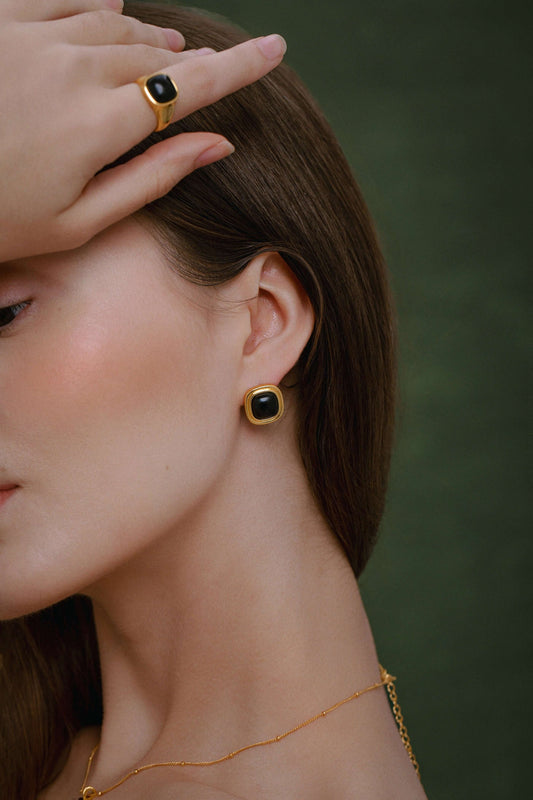 Woman wearing SUIHE Jewelry Black Onyx Square Ring and matching earrings in 18k gold vermeil, showcasing modern elegance.