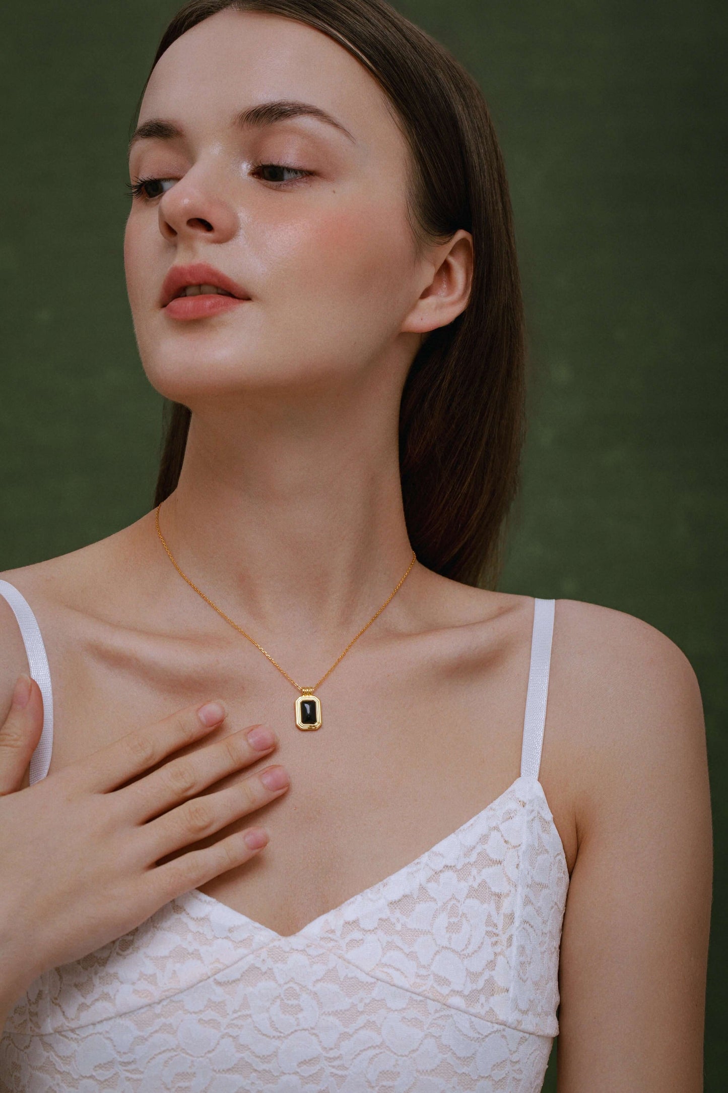 Woman wearing SUIHE Jewelry "Nocturne" black onyx rectangle necklace in 18k gold vermeil, symbolizing protection and inner strength.