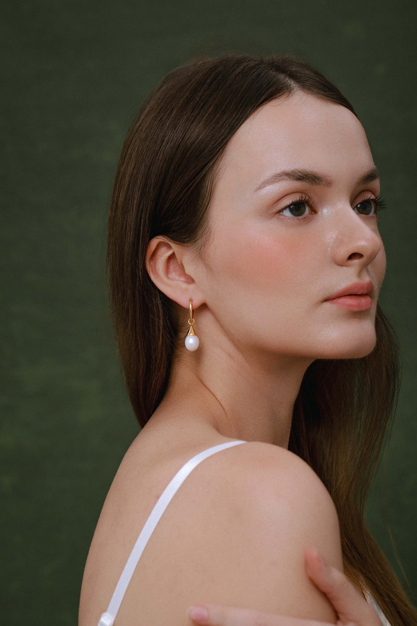 Woman wearing SUIHE Jewelry's Dewdrop freshwater pearl earrings with gold-plated sterling silver.